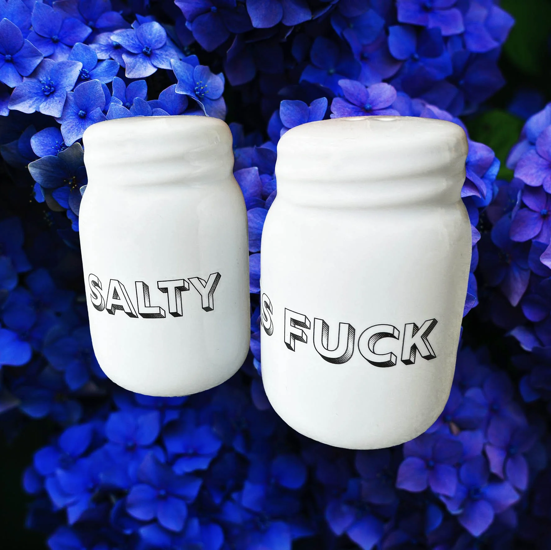 White salt and pepper shakers with the words “salty” and “as fuck” in black lettering