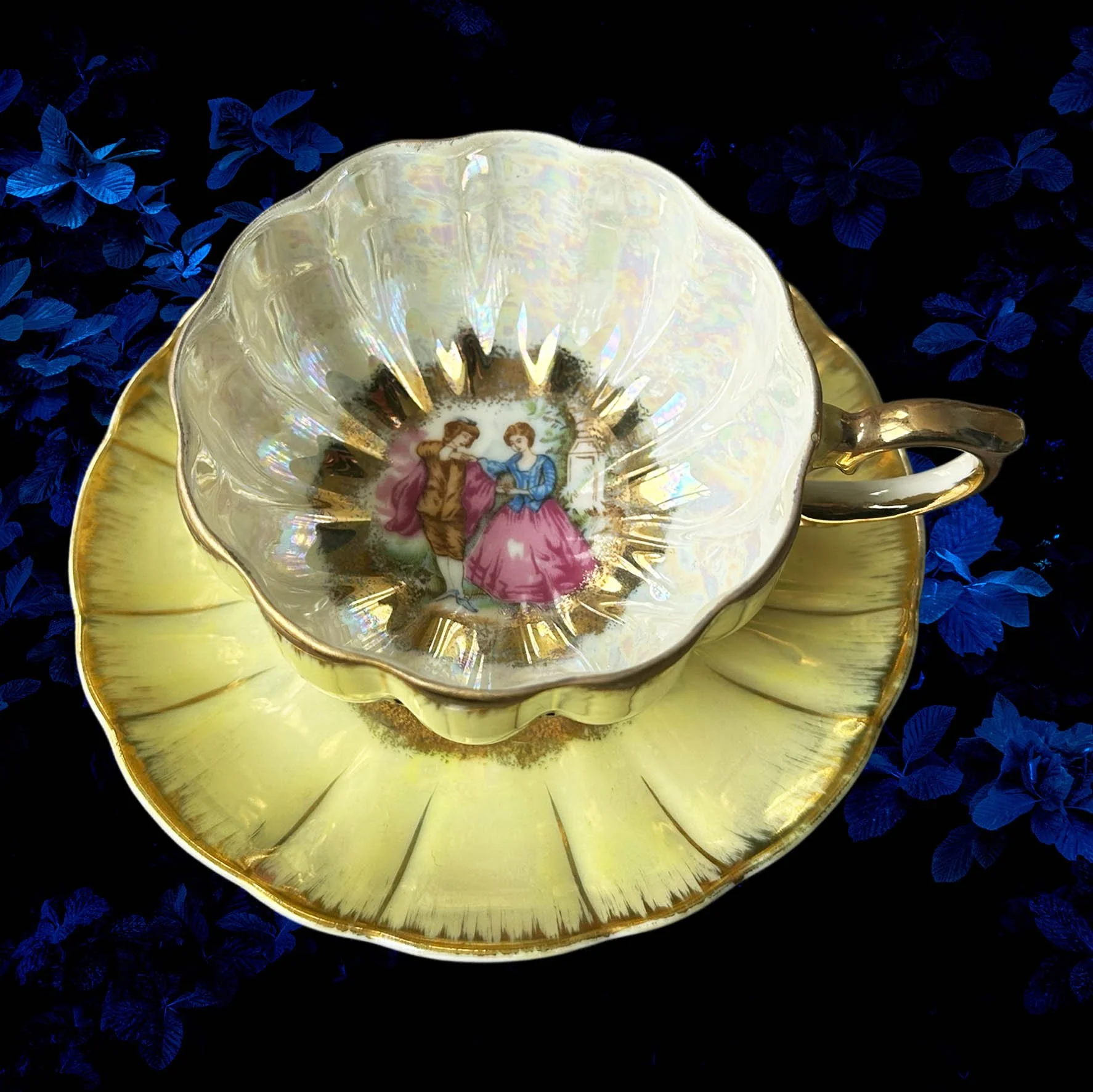 A yellow scalloped shaped tea cup with a picture of a couple and the words "In a world full of cunts you're my favourite"