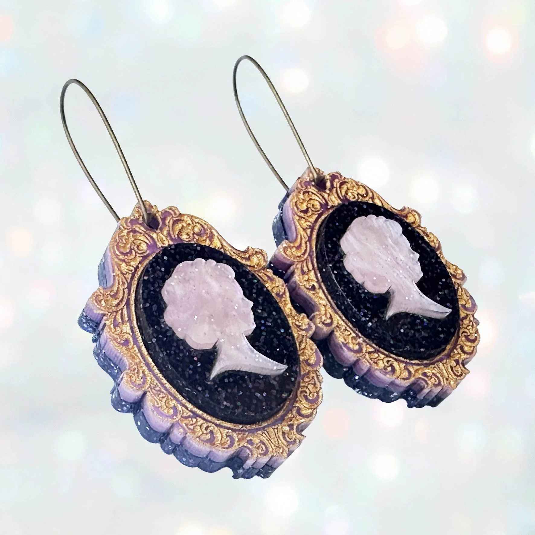 Laser cut pink and purple acrylic cameo style earrings featuring a silhouette