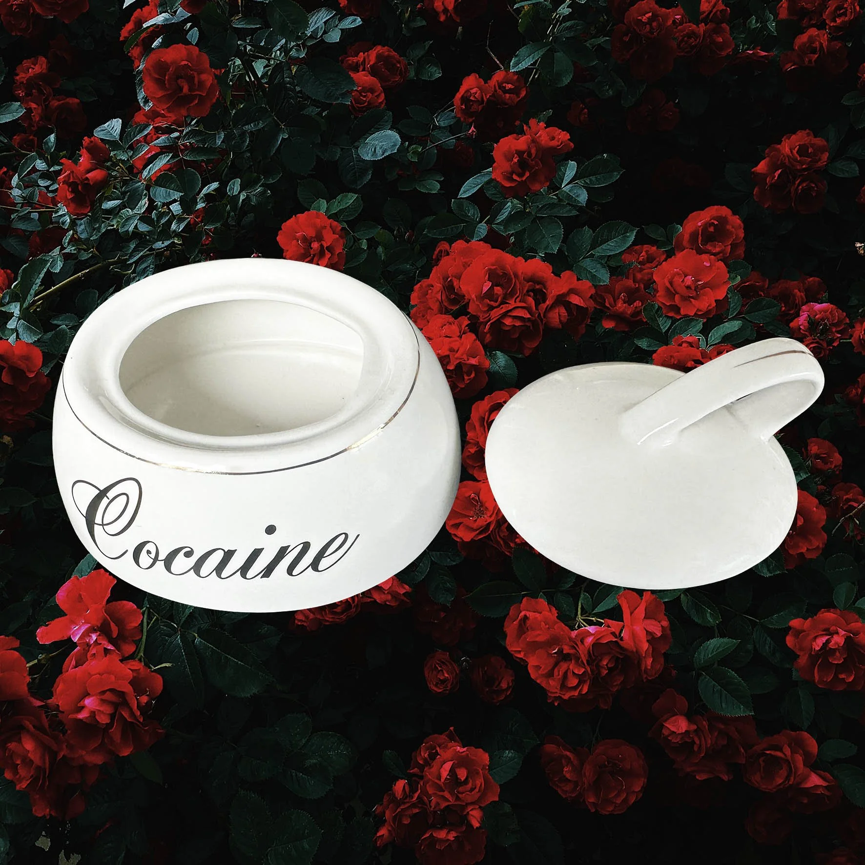 A vintage trinket jar with the word “cocaine” in black writing