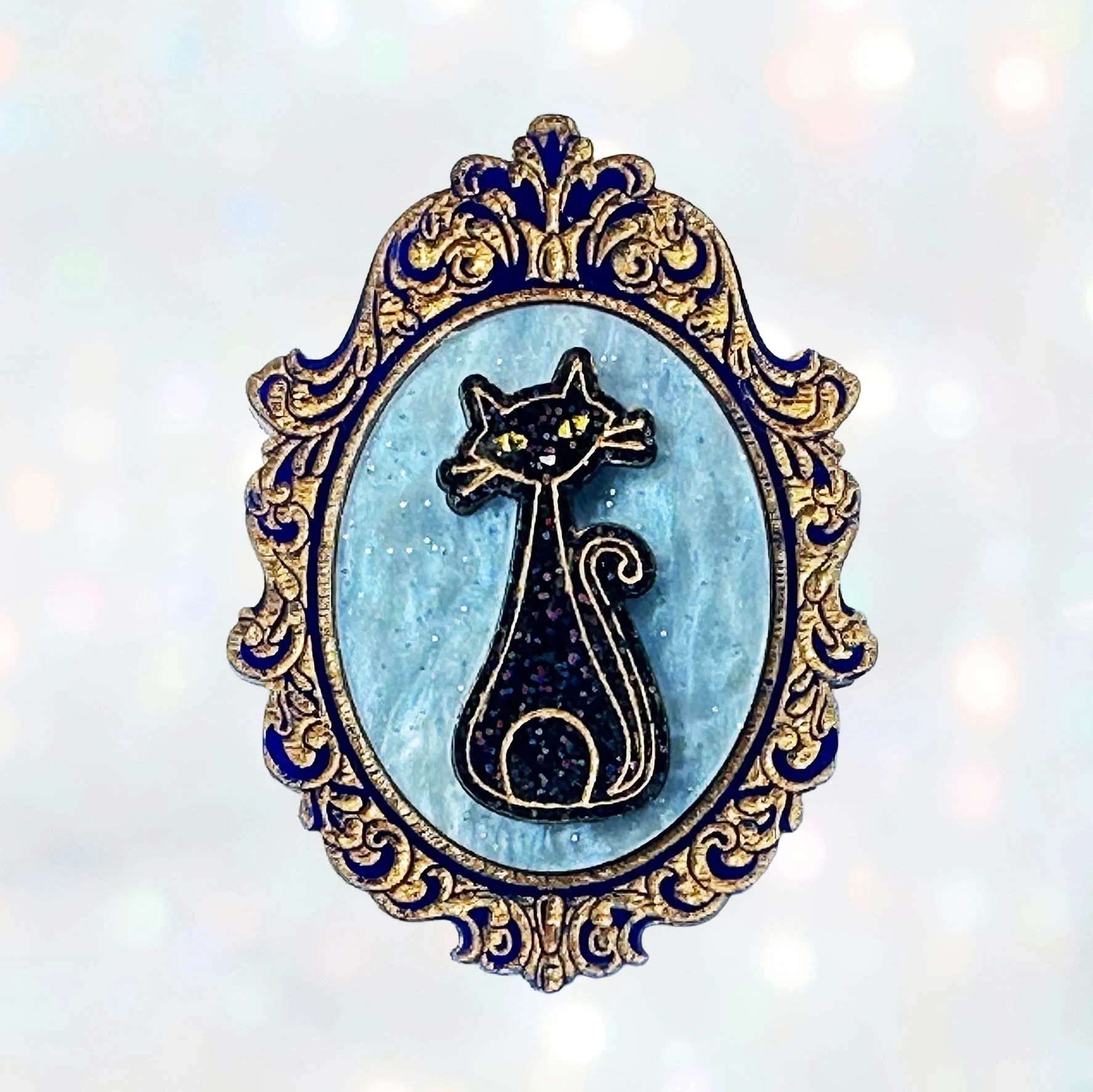 Laser cut acrylic cameo style brooch featuring black cats inside gold frames