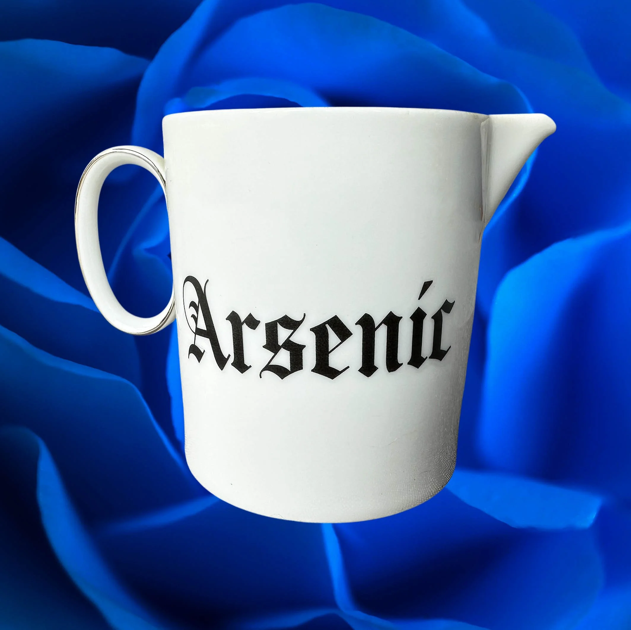Vintage white Thomas milk jug with the word “Arsenic” in black gothic style lettering