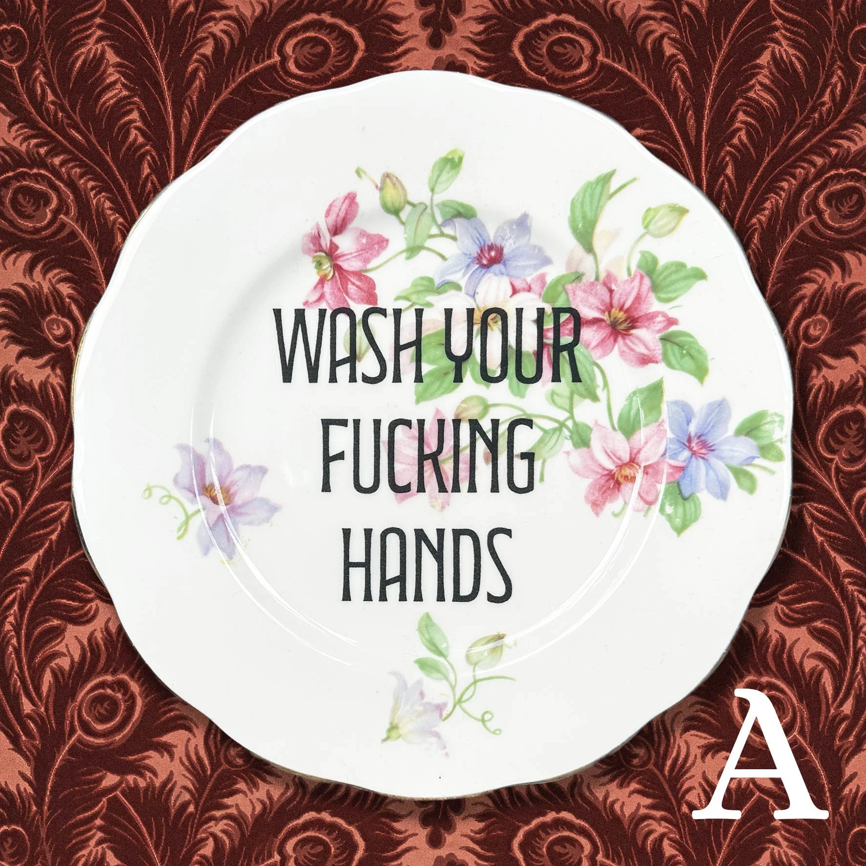Plate A: a vintage plate with a floral design and the quote “wash your fucking hands”