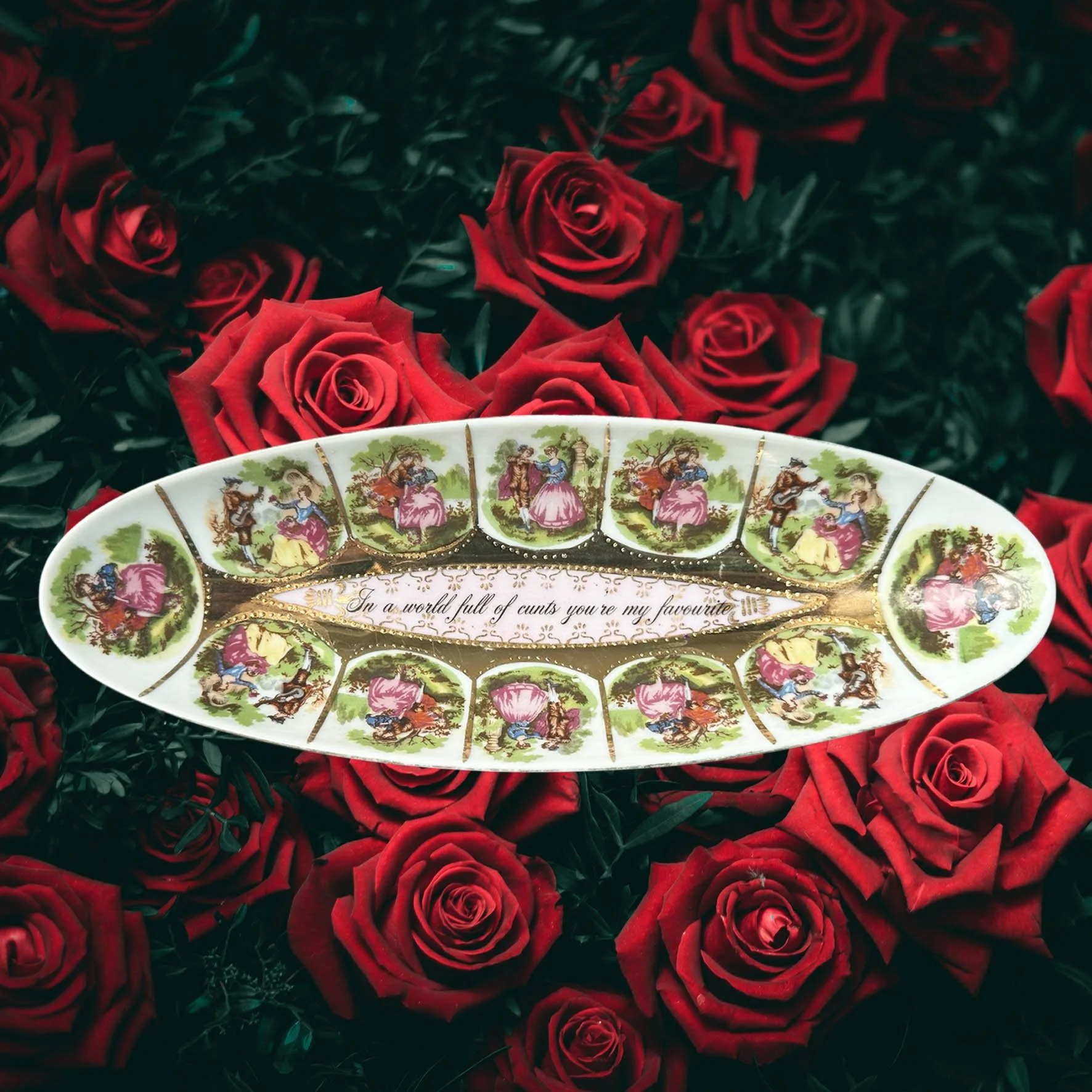 a vintage dish with pictures of a couple and the words "In a world full of cunts you're my favourite"