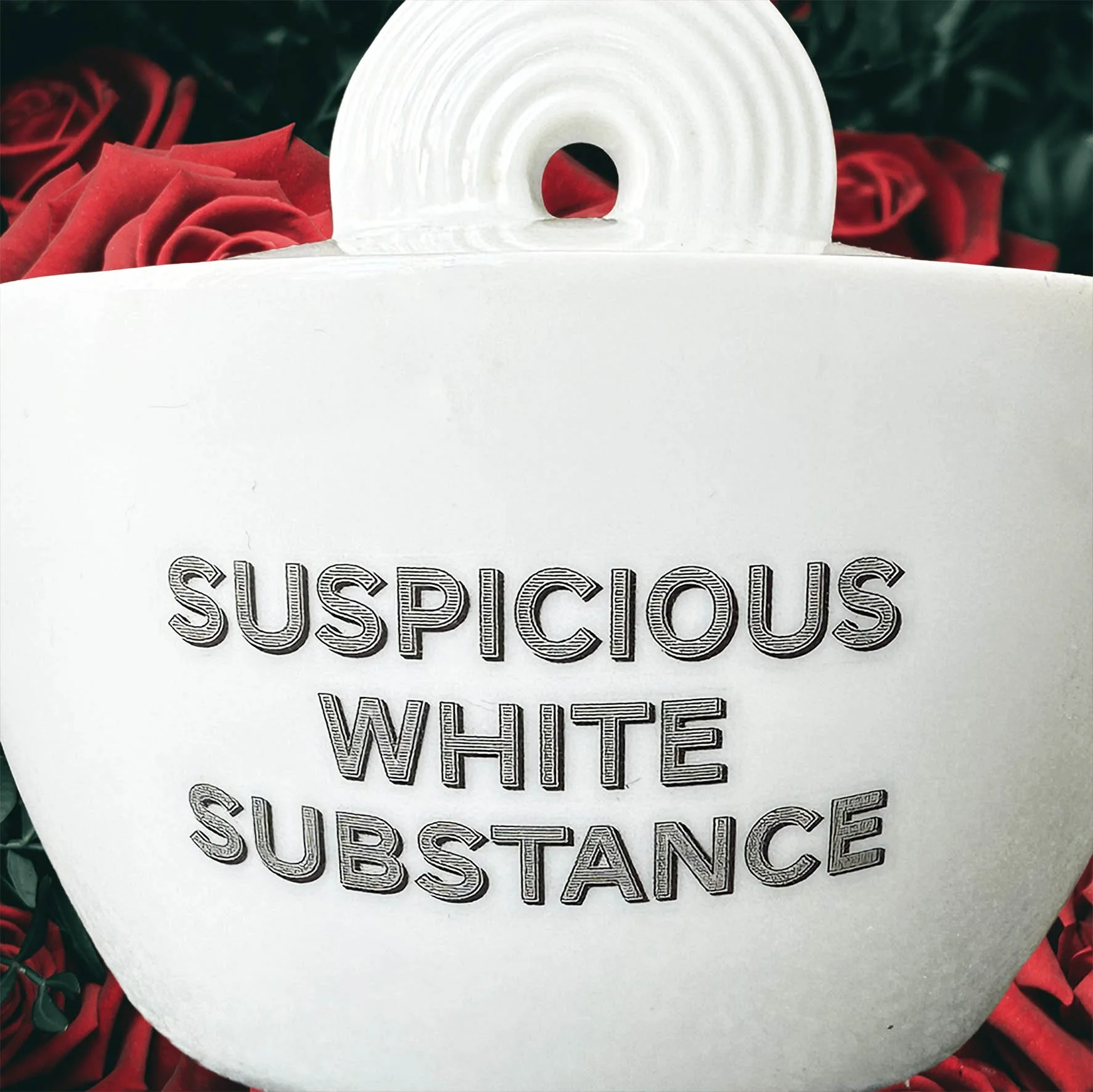 A white Thomas Germany sugar bowl with the quote “suspicious white substance” in black lettering