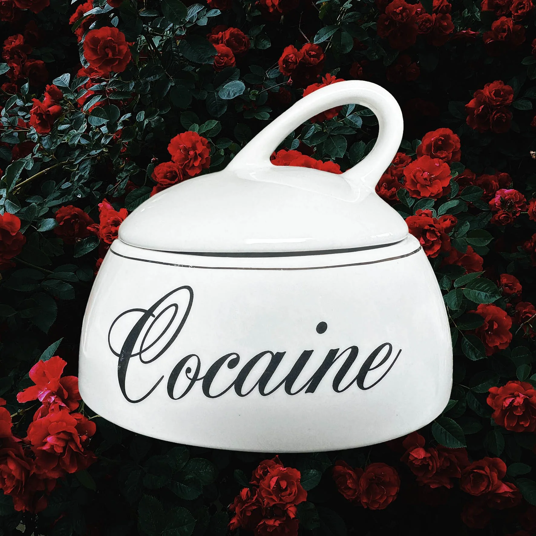A vintage trinket jar with the word “cocaine” in black writing