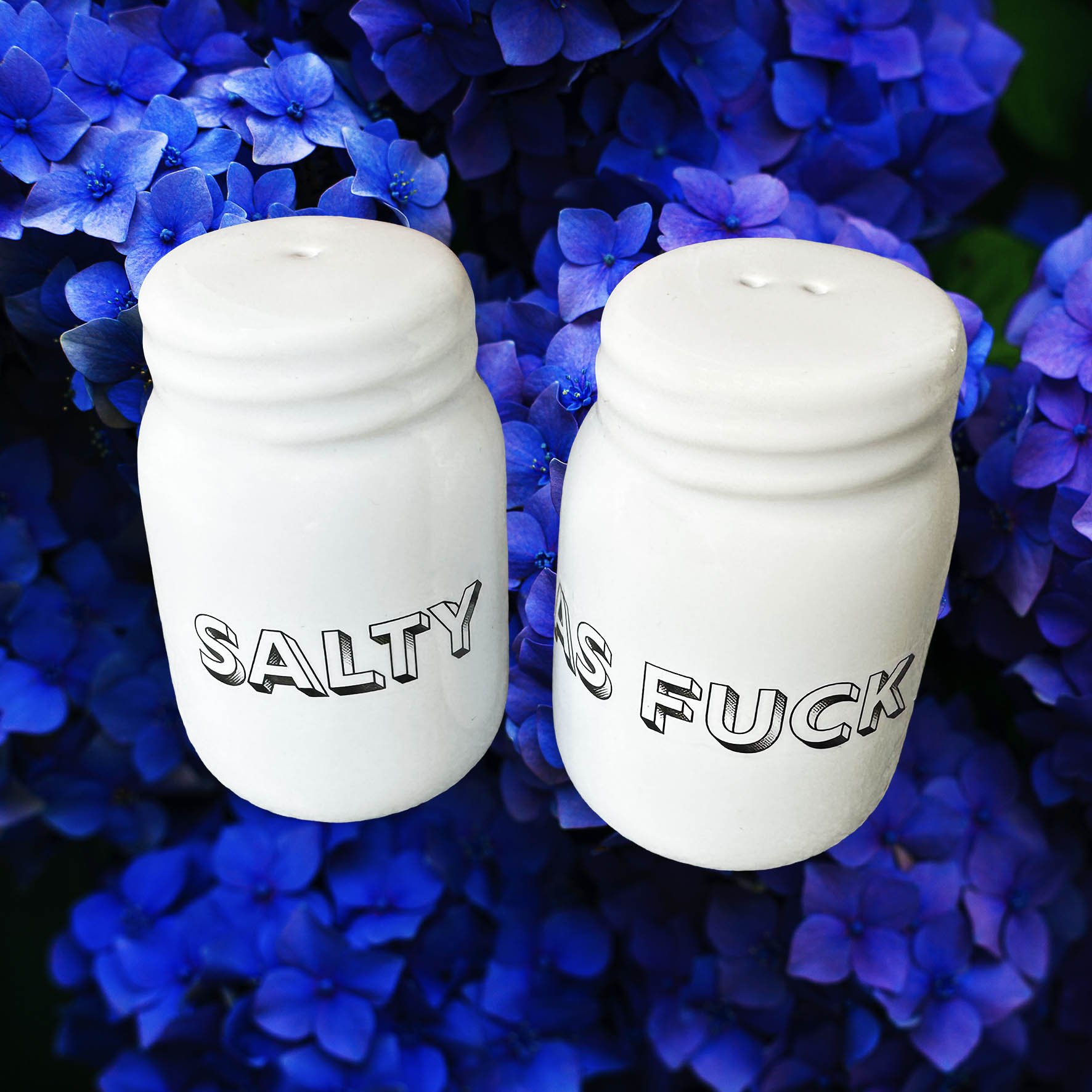 White salt and pepper shakers with the words “salty” and “as fuck” in black lettering