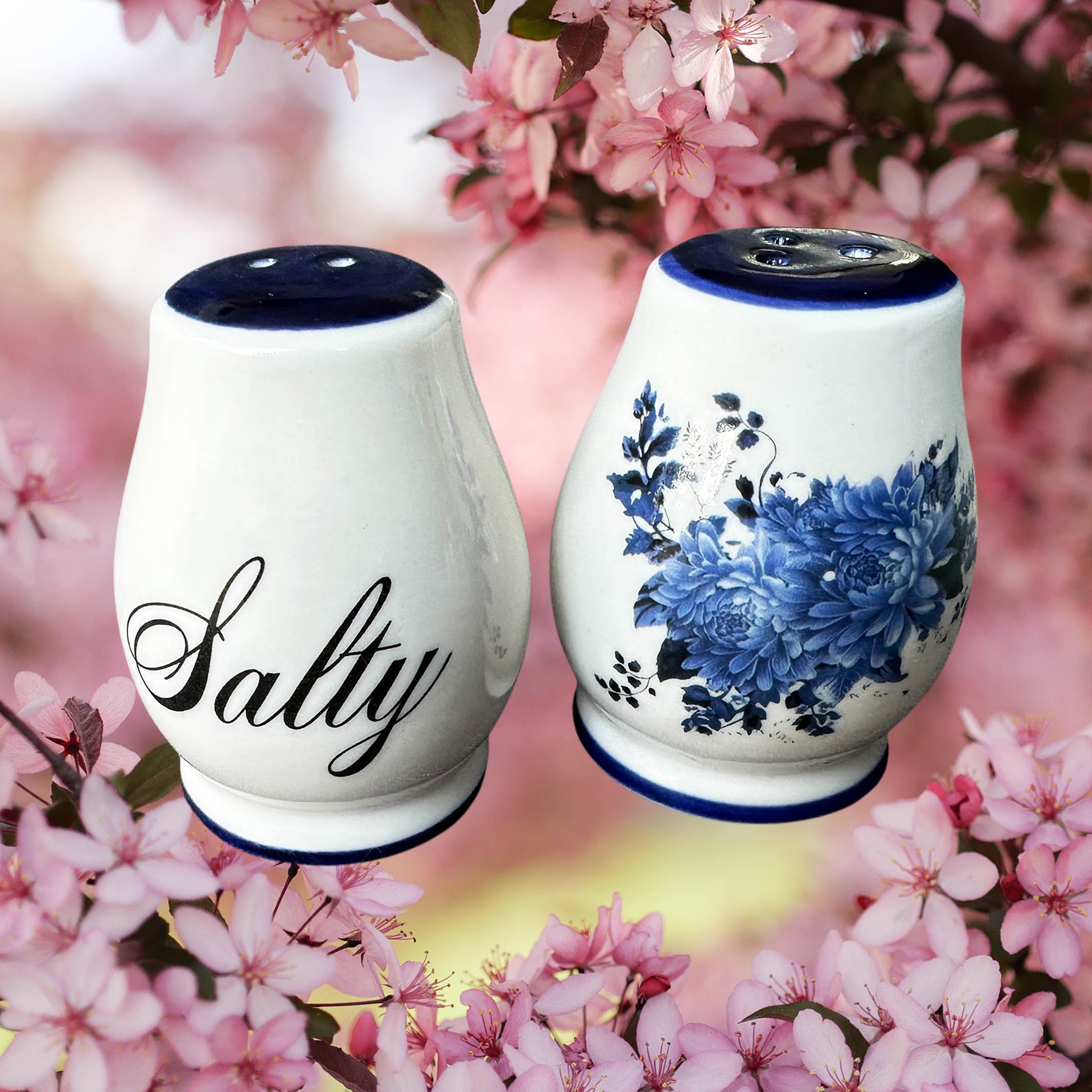 White salt and pepper shakers with blue flowers, the words “salty” and “bitch” in black cursive writing