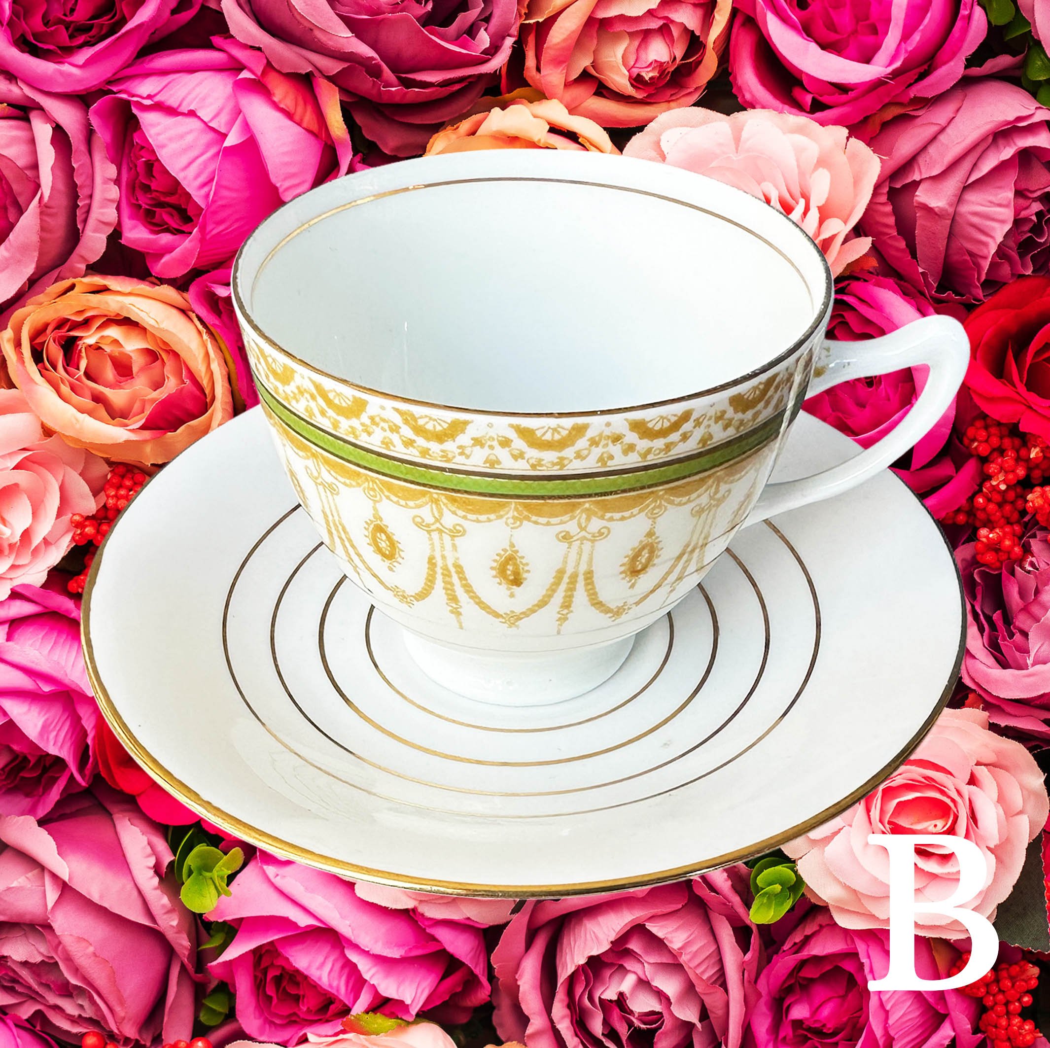 A vintage tea cup witha green and gold floral design and the word "poison" in black cursive writing