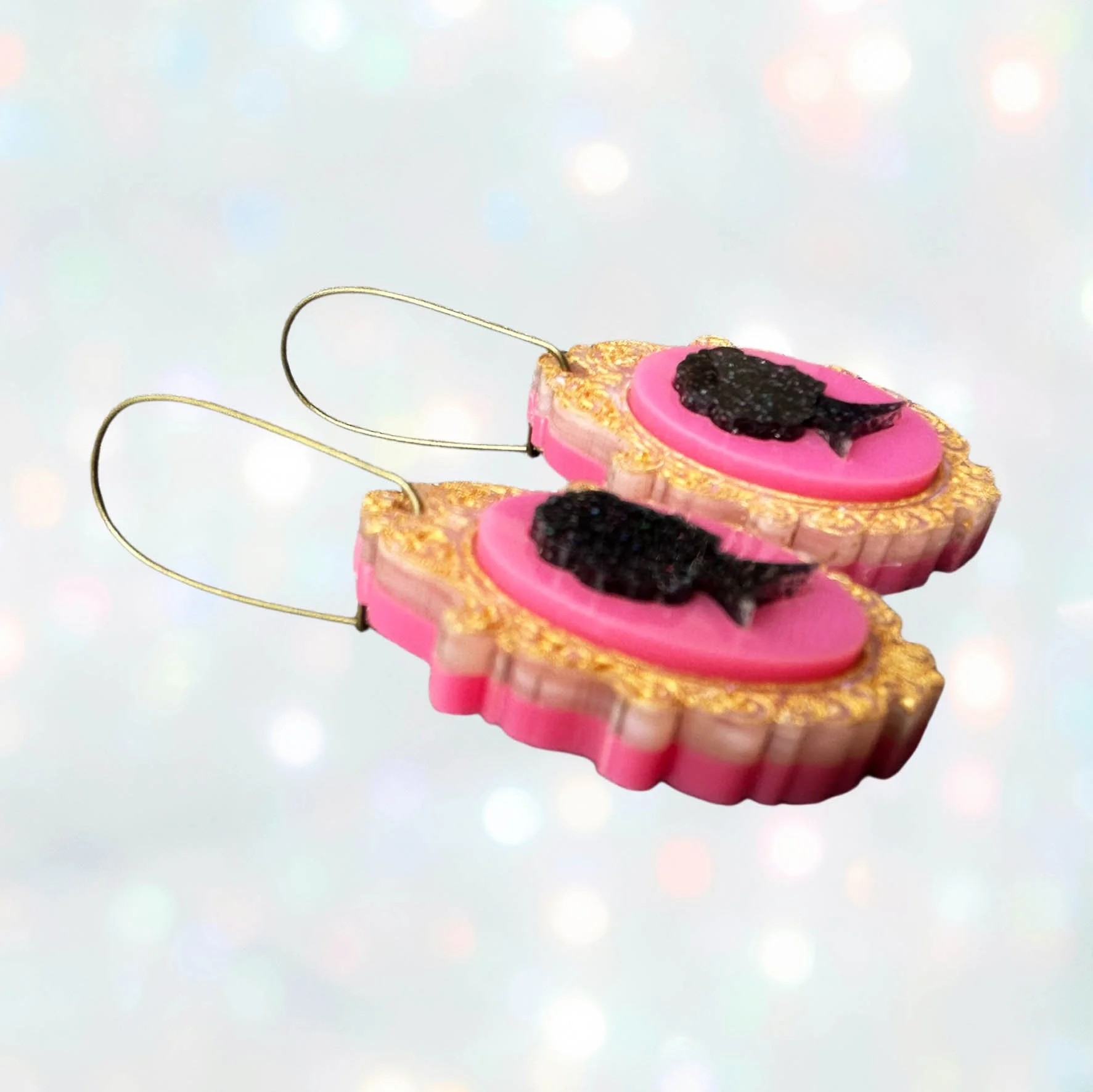 Laser cut acrylic earrings in a cameo style, pink gold and black glitter