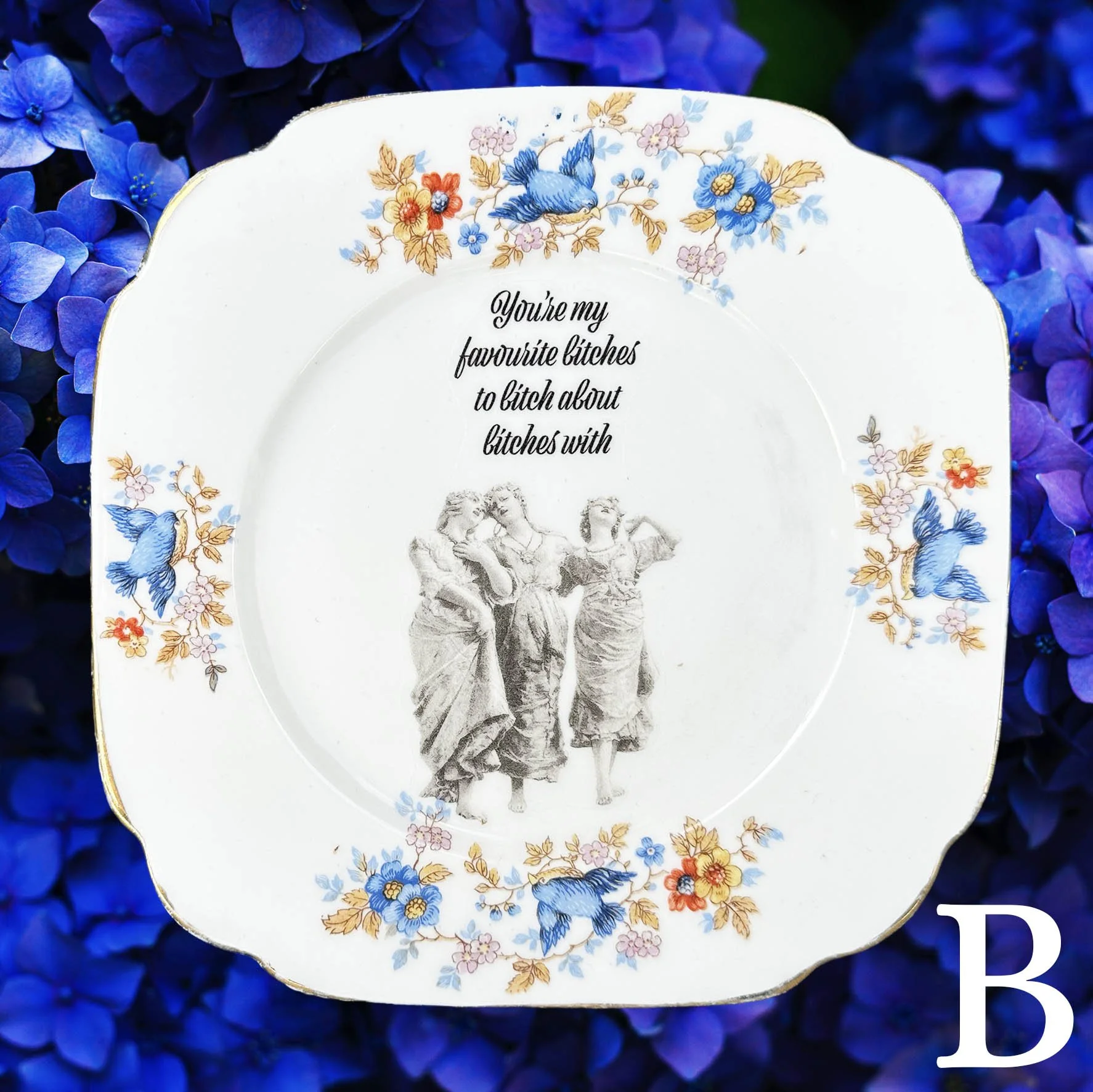 A vintage plate with a blue floral border and the quote “you’re my favourite bitches to bitch about bitches with”