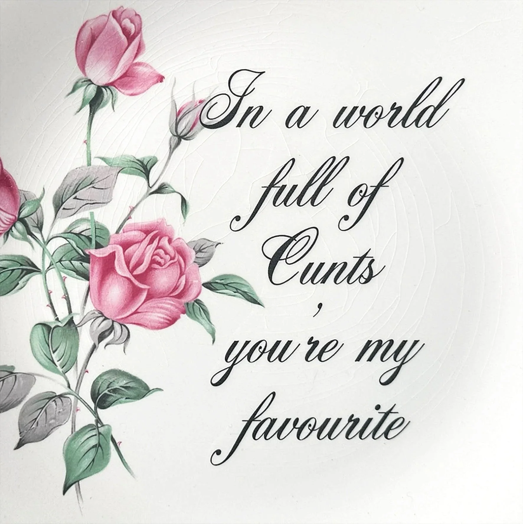 A vintage plate with pink roses and the words "In a world full of cunts you're my favourite"