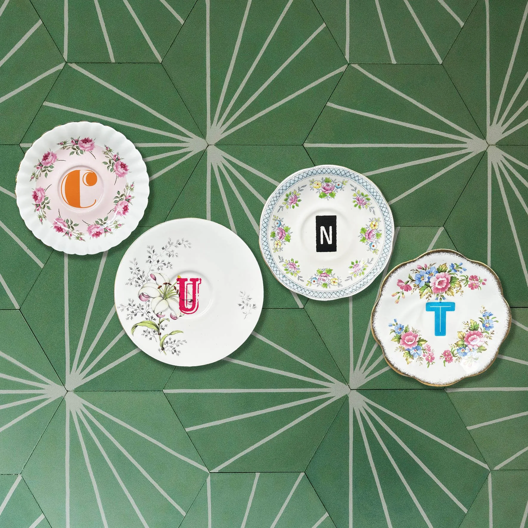 A vintage saucer plate set spelling out the word “cunt”