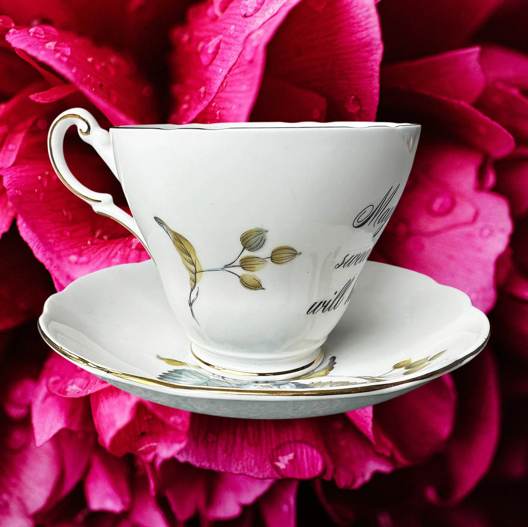 A vintage tea cup with a blue floral design and the words "maybe swearing will help" in black writing