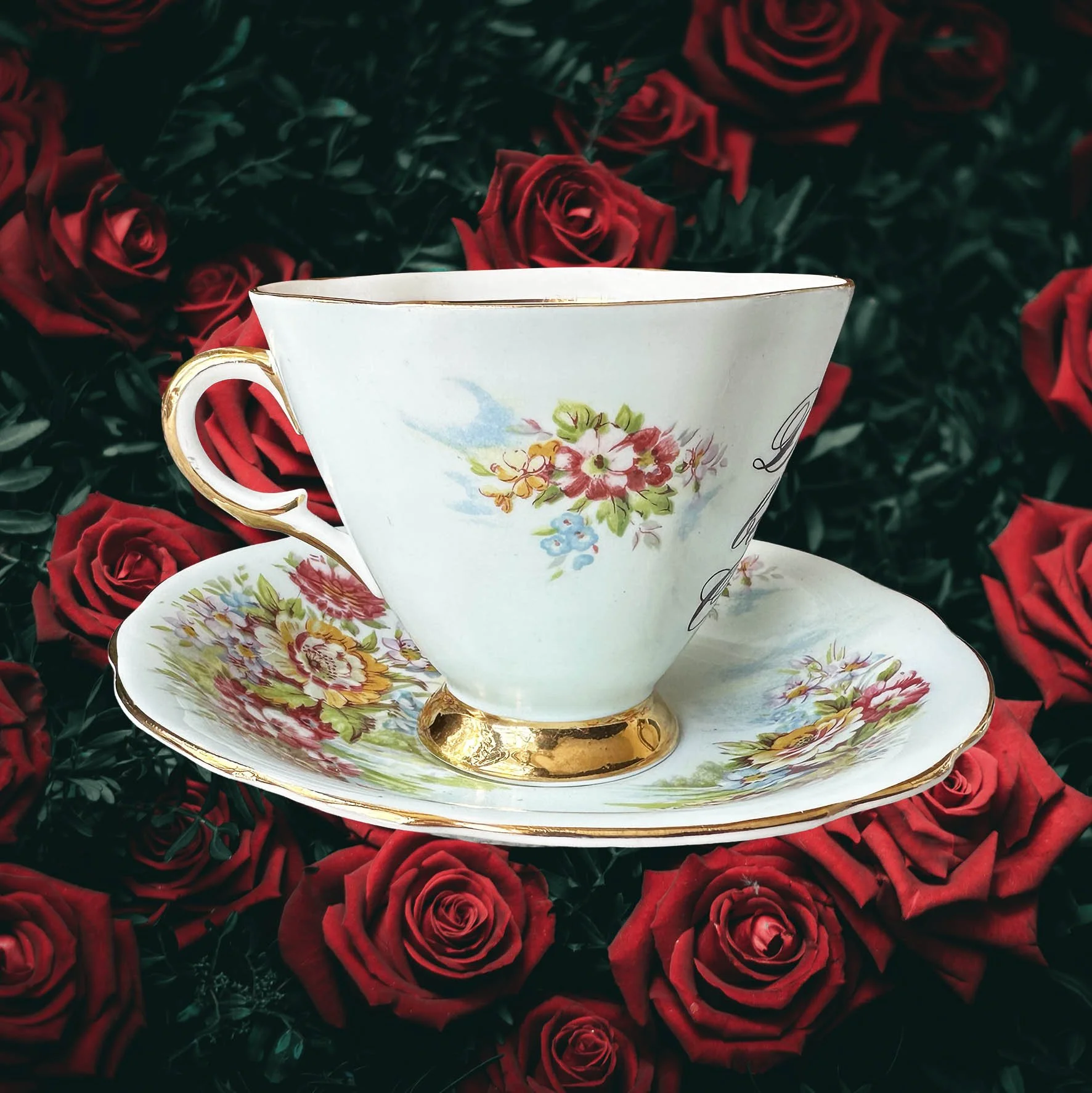 A vintage tea cup and saucer, light blue with a floral design and the quote “don’t be a cunt” in black writing
