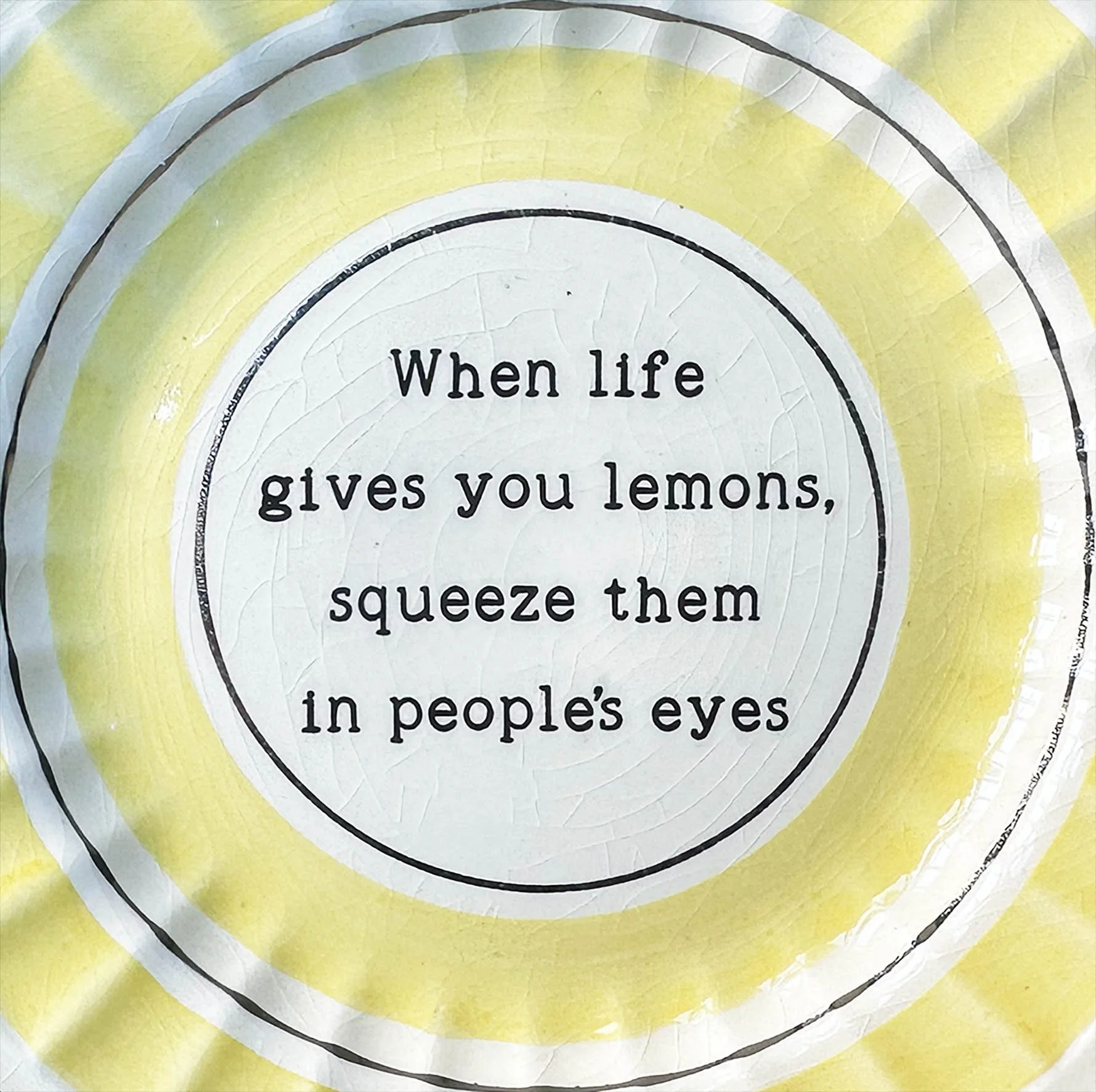 A yellow and white plate with the quote “when life wives you lemons, squeeze them in people’s eyes”