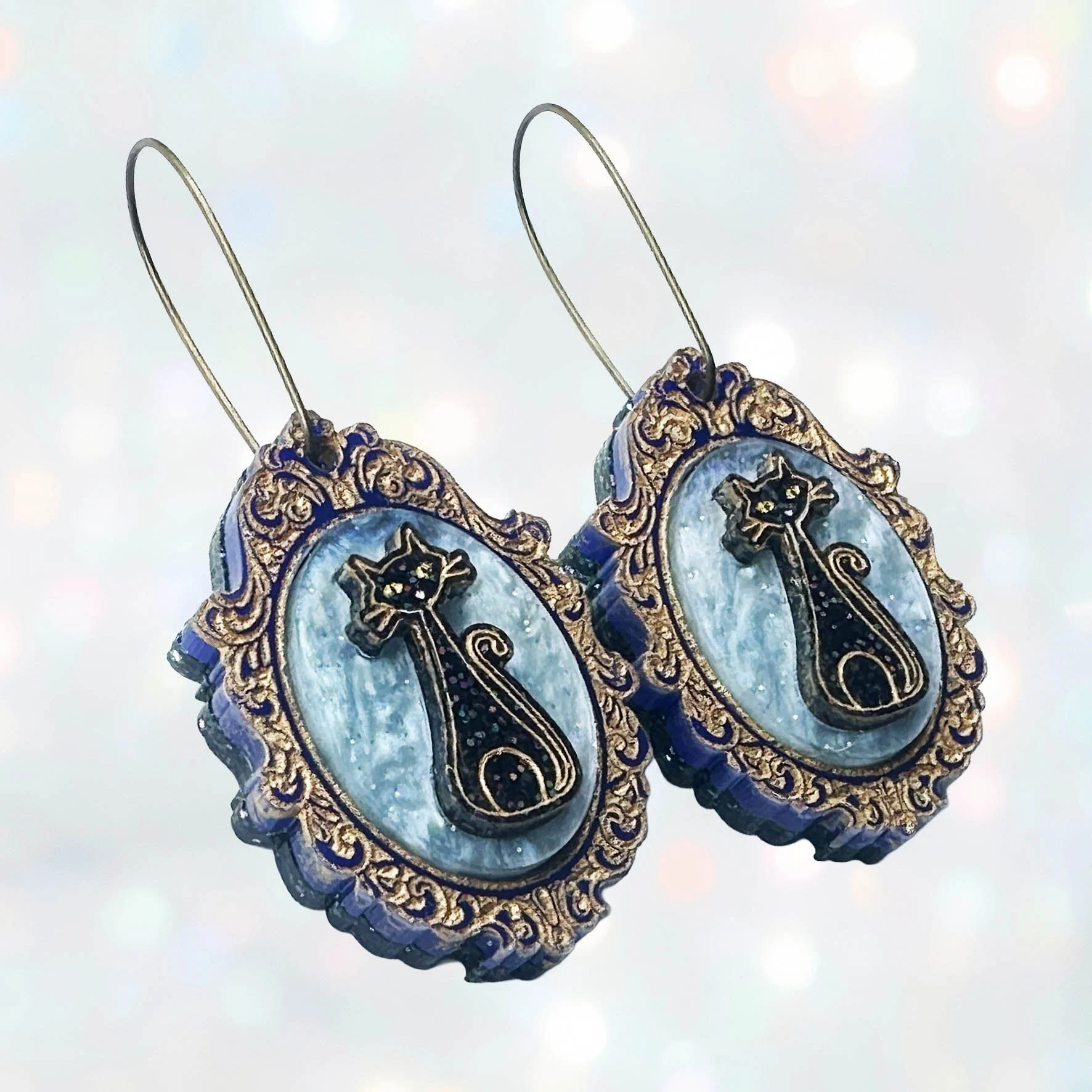 Laser cut cameo style earrings featuring black cats inside gold frames
