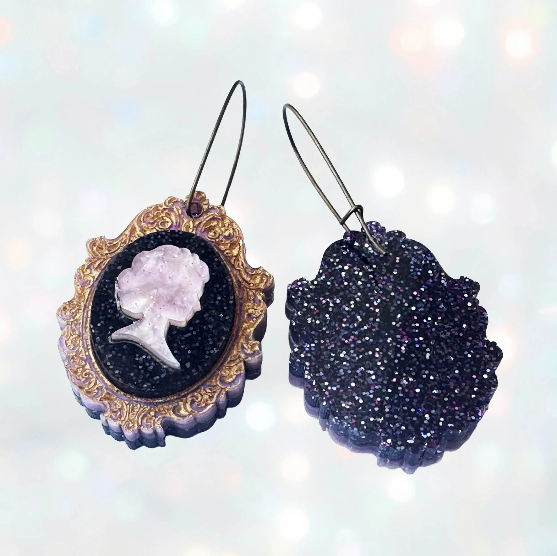 Laser cut pink and purple acrylic cameo style earrings featuring a silhouette