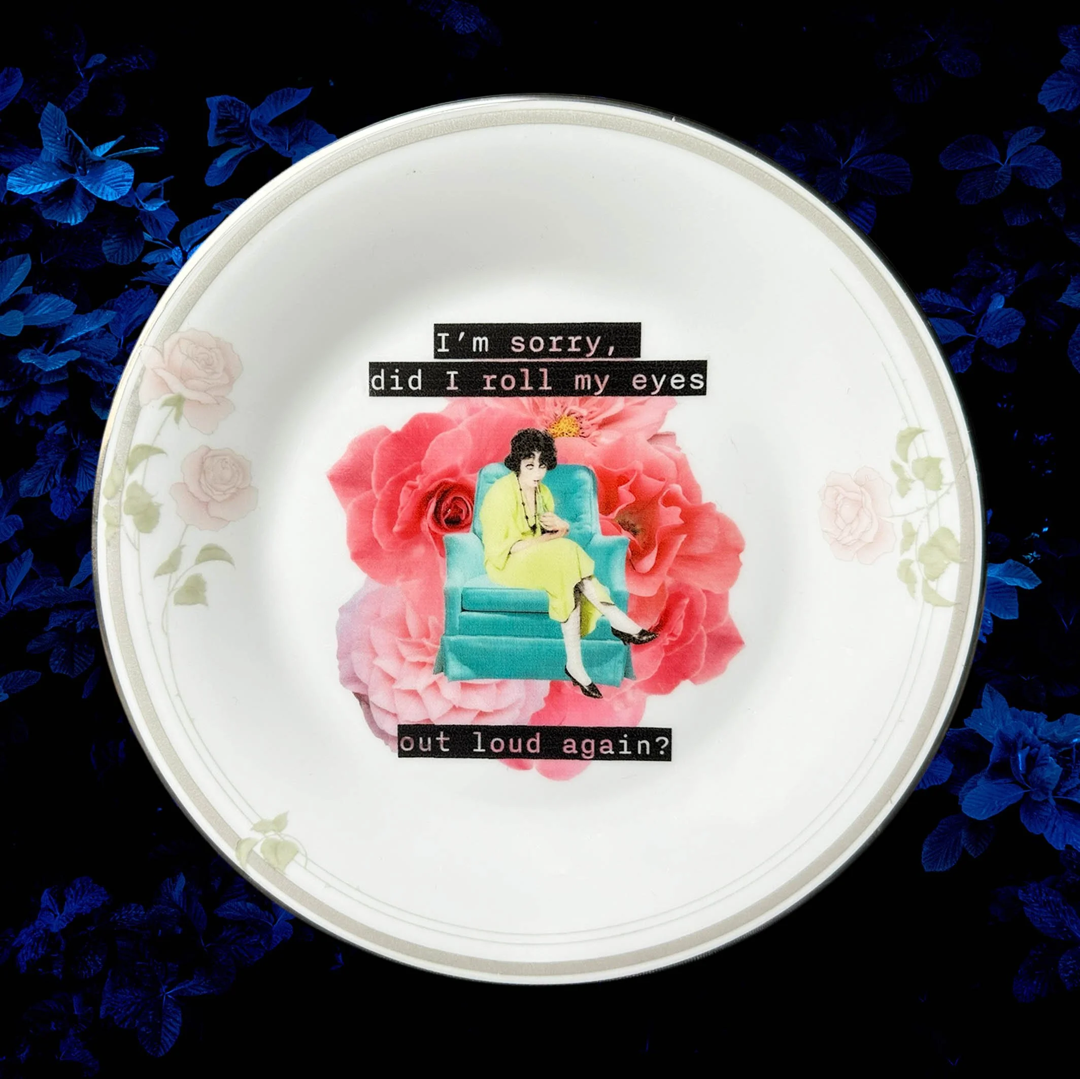 A vintage plate with a pink rose border and a picture of a woman sitting on a blue chair with a drink, and the words “I’m sorry, did I roll my eyes out loud?”