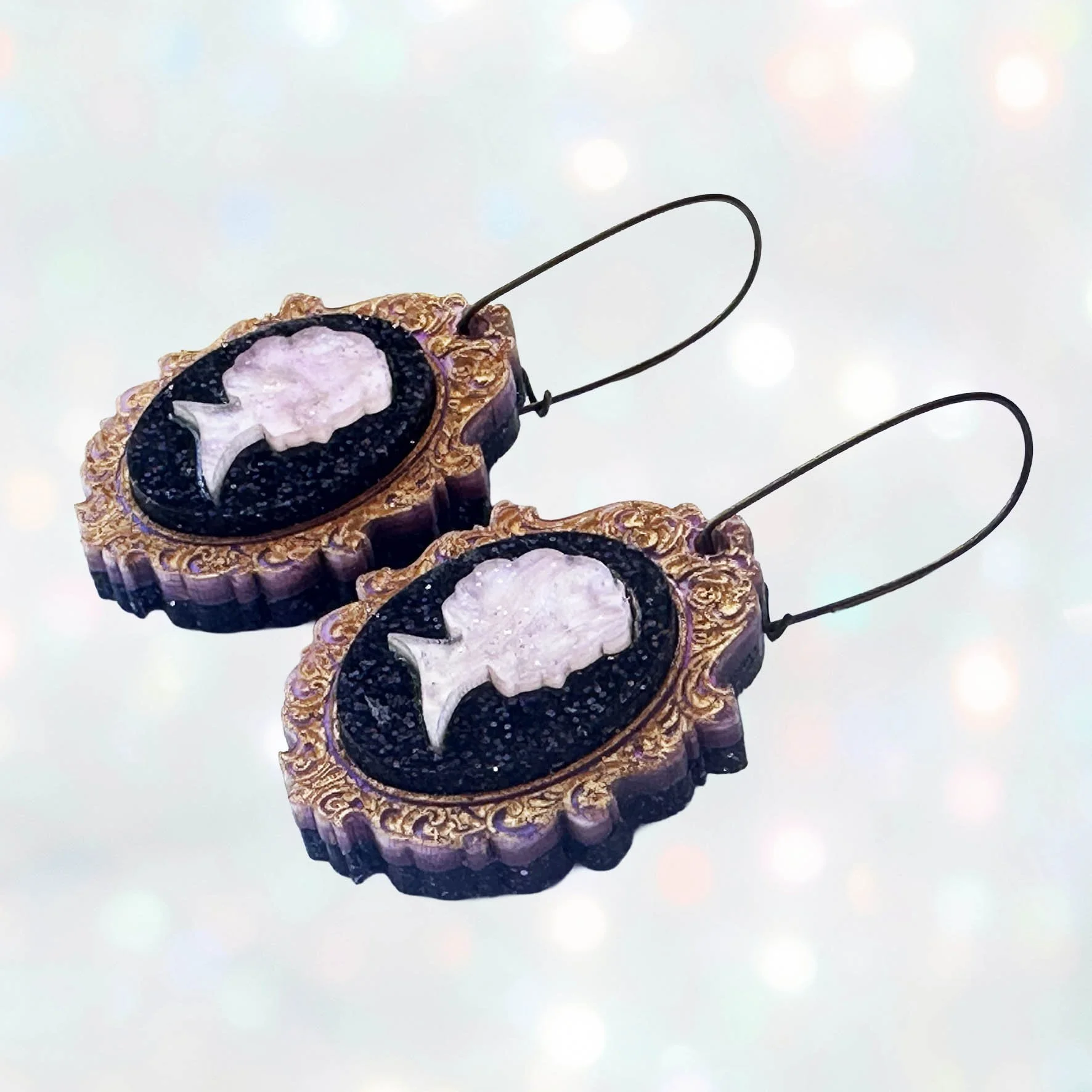 Laser cut pink and purple acrylic cameo style earrings featuring a silhouette