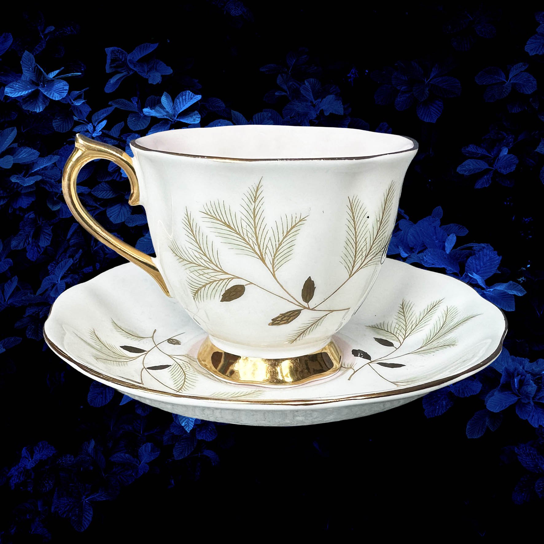 A vintage tea cup with a floral design with the quote “badass bitch”