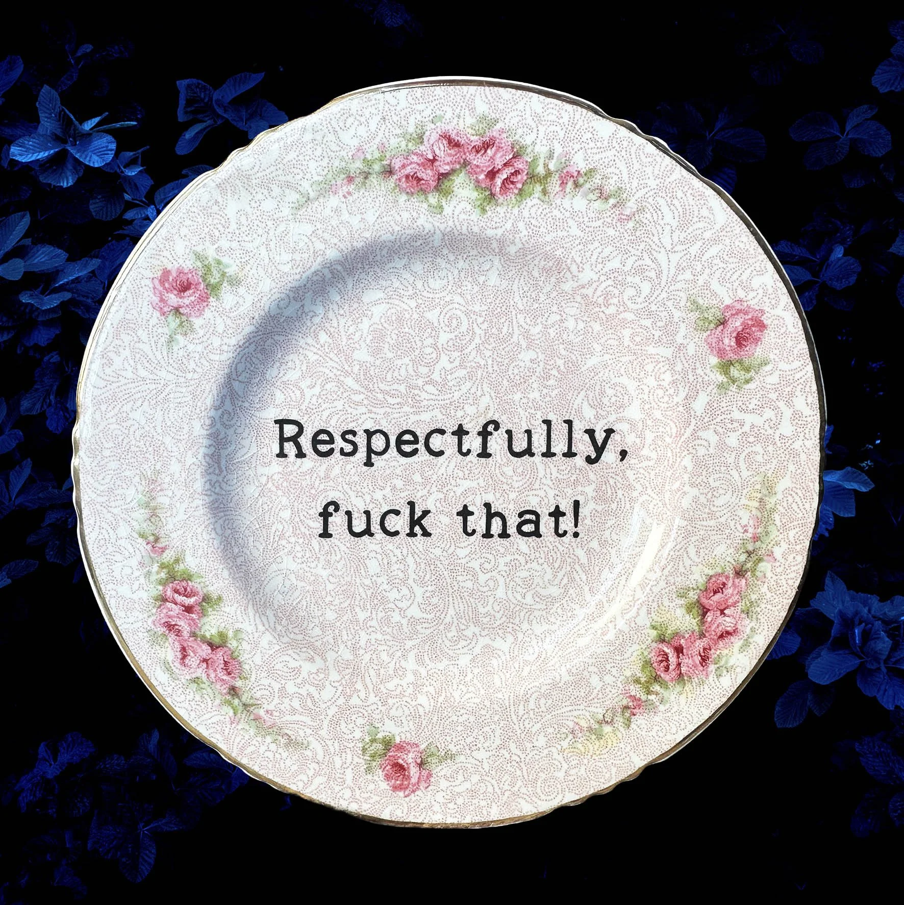 A vintage plate with a pink floral design and the quote “respectfully, fuck that!”