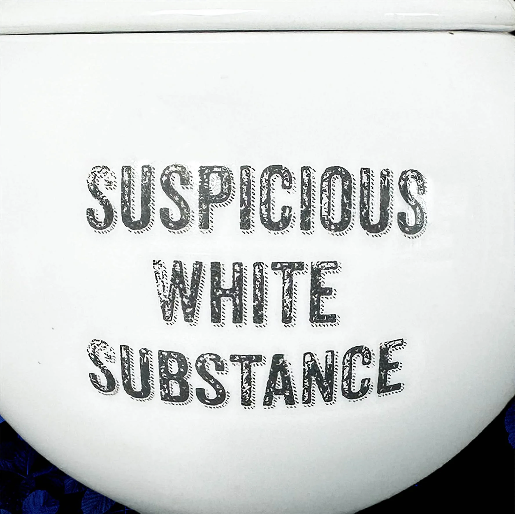 A round white sugar bowl with the words "suspicious white substance" in black lettering