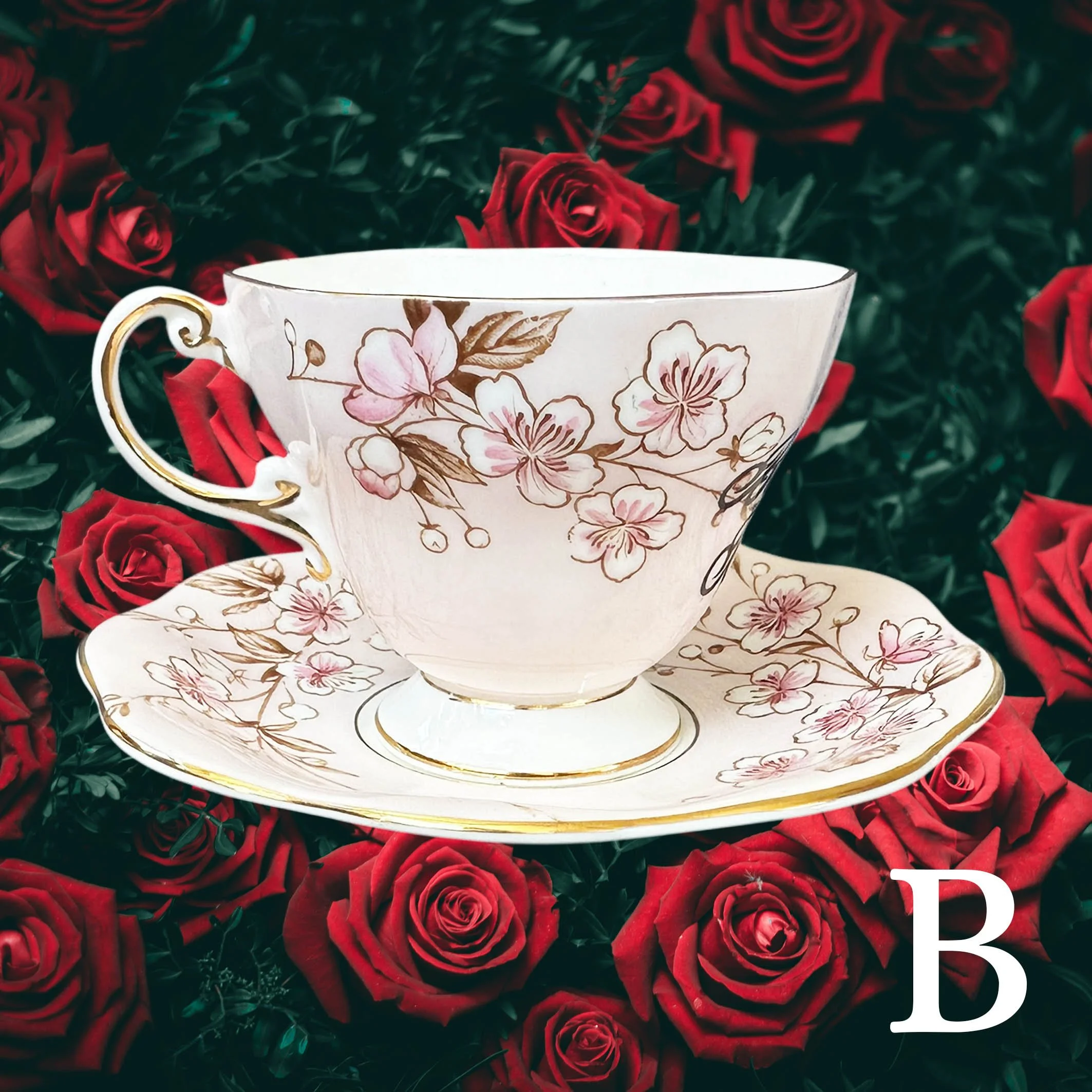 A soft pink vintage tea cup and saucer set with a pink floral design, with the words "badass bitch" in black cursive writing