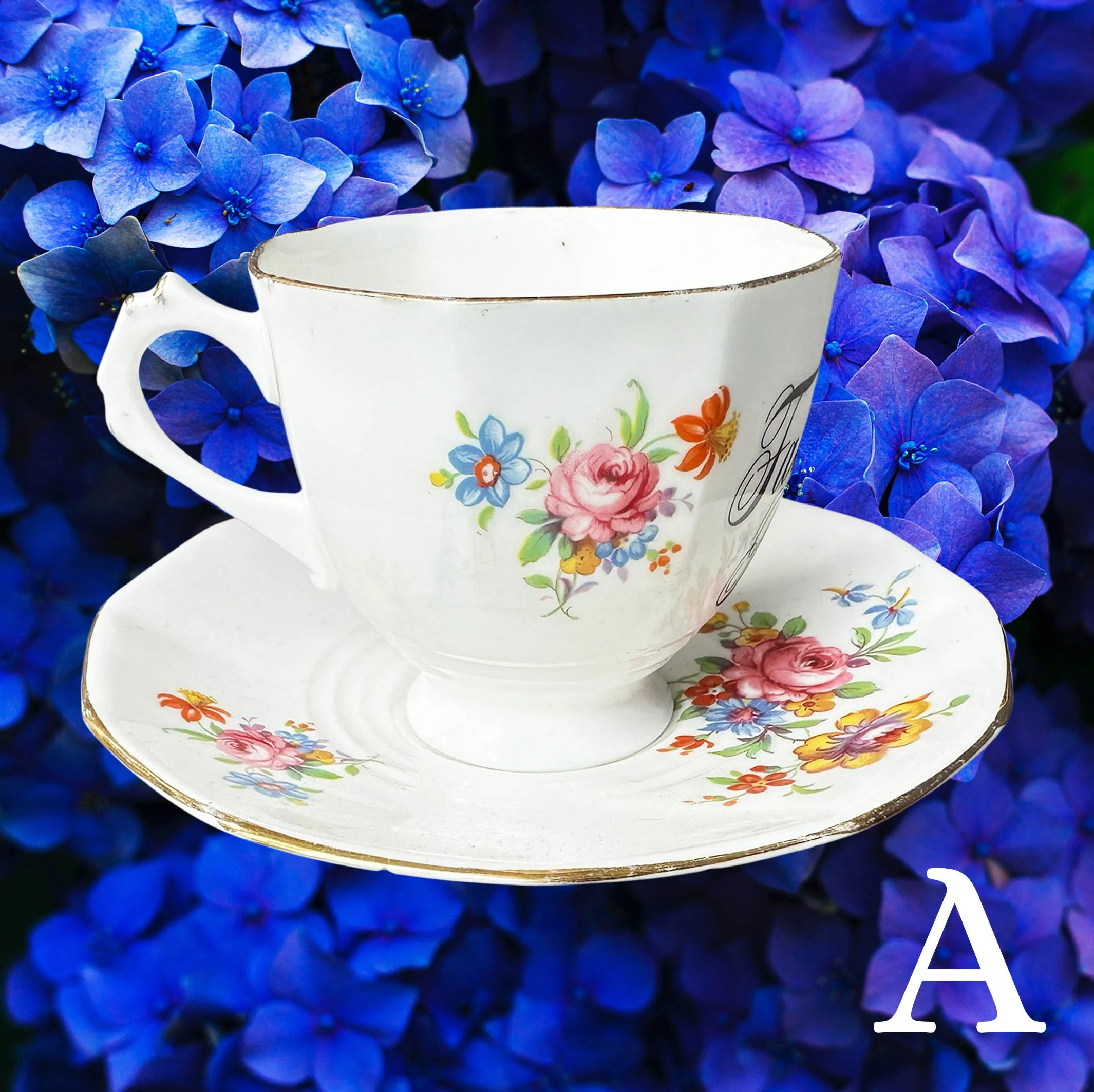 A vintage tea cup with delicate multicoloured flowers and the words “fabulous bitch” in black cursive writing