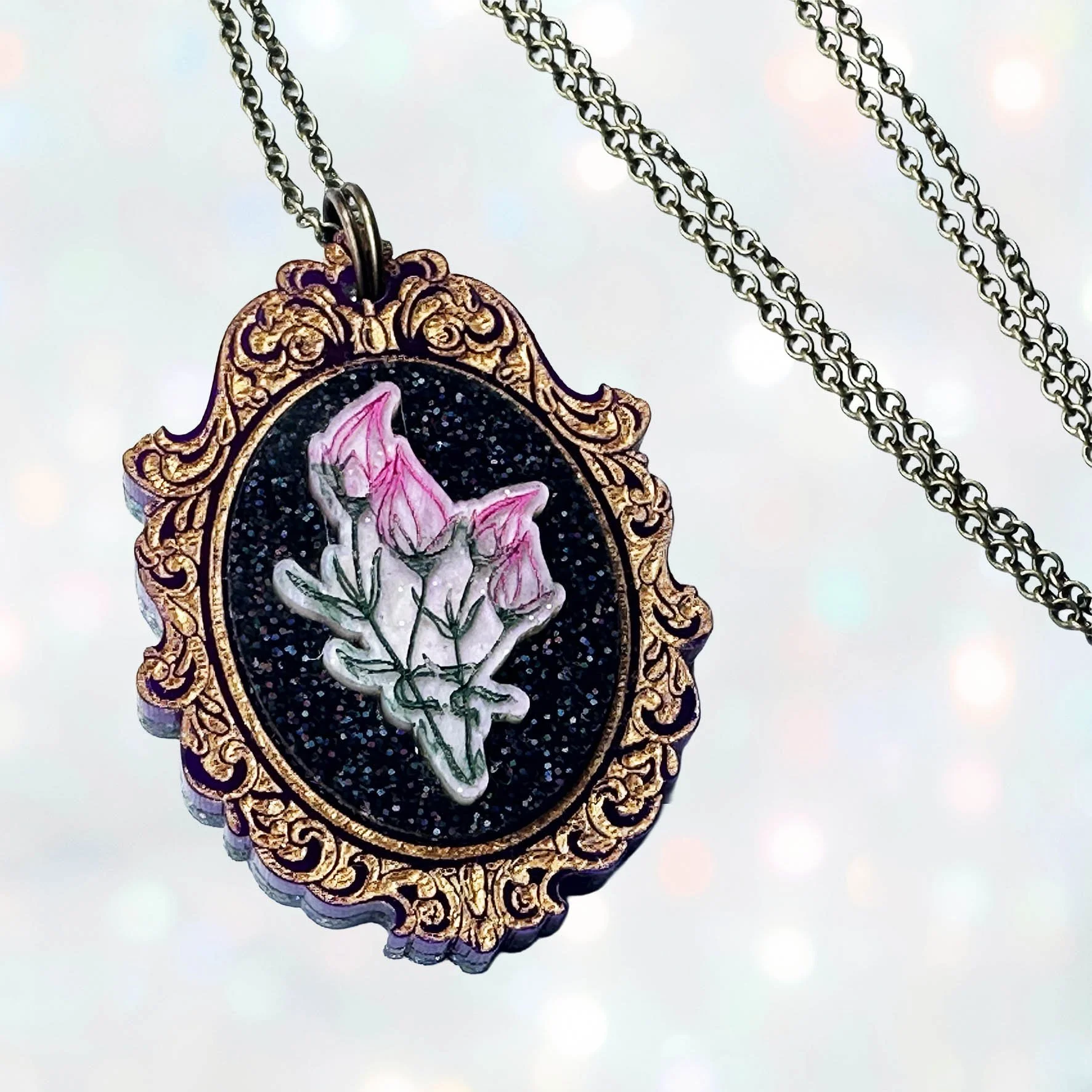 Laser cut acrylic cameo necklace featuring a bunch of flowers inside a gold frame