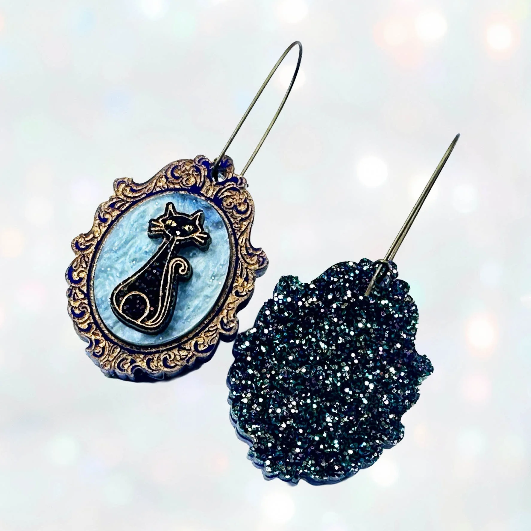 Laser cut cameo style earrings featuring black cats inside gold frames