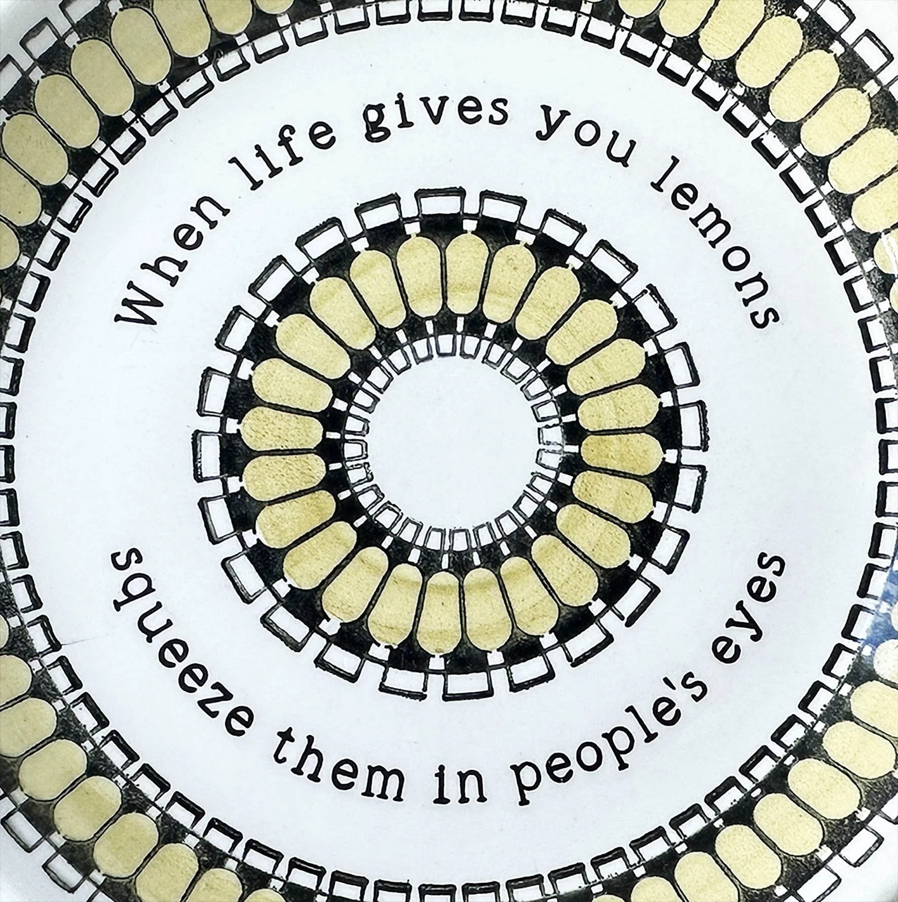 A yellow and white plate with the quote “when life wives you lemons, squeeze them in people’s eyes”