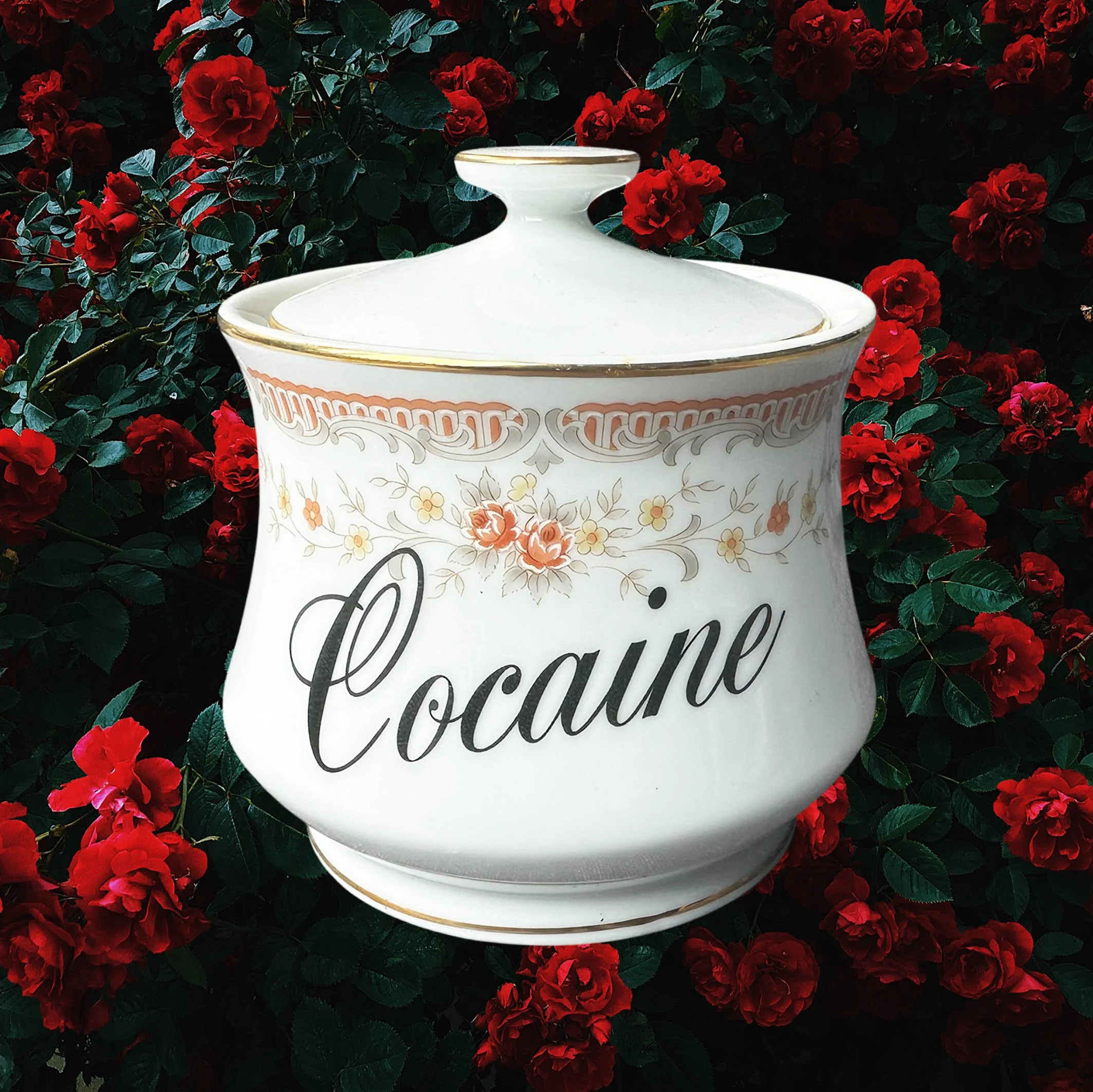 A vintage Japanese sugar bowl with a peach coloured floral design and the words “cocaine” in black cursive writing