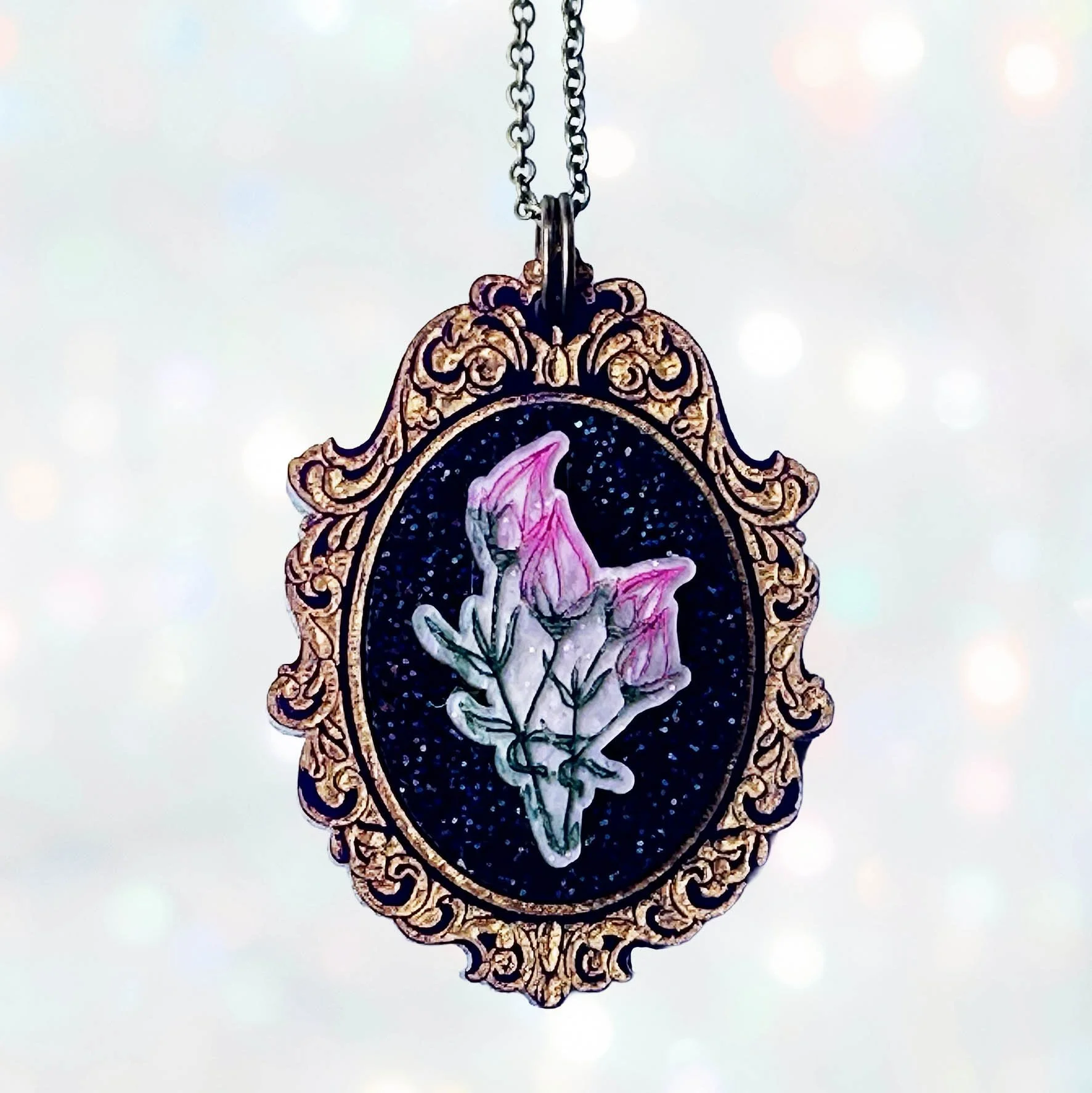 Laser cut acrylic cameo necklace featuring a bunch of flowers inside a gold frame