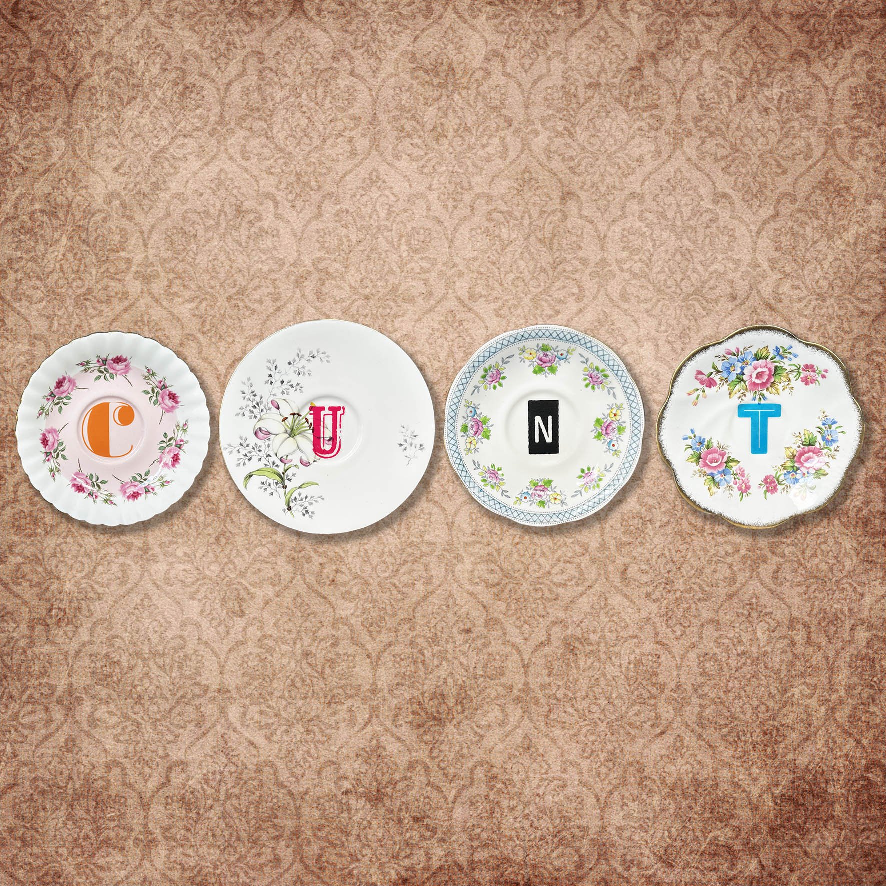 Set of four saucers spelling out the word “cunt”