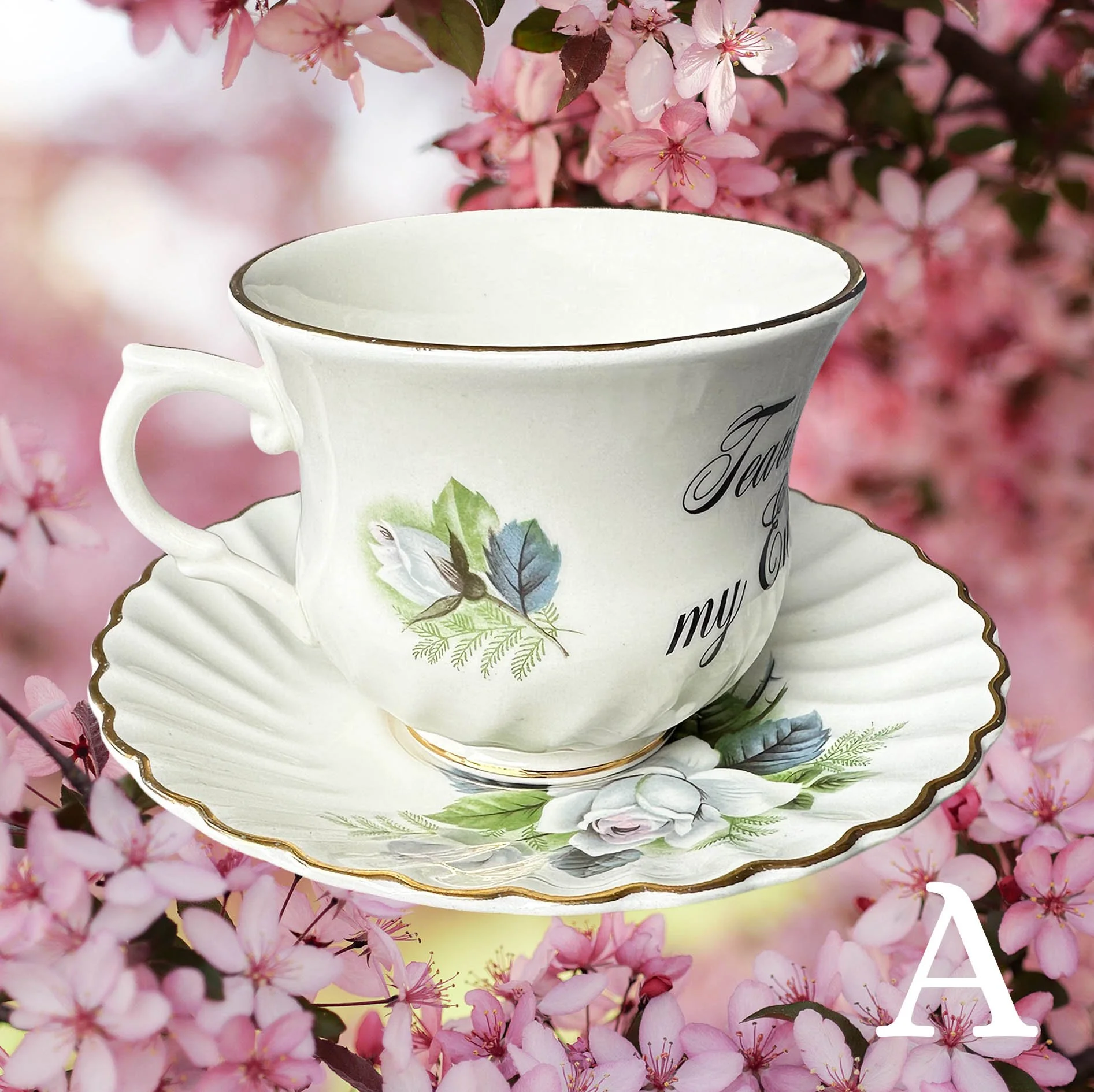A vintage tea cup with a blue floral design and the words "tears of my enemies" in black writing