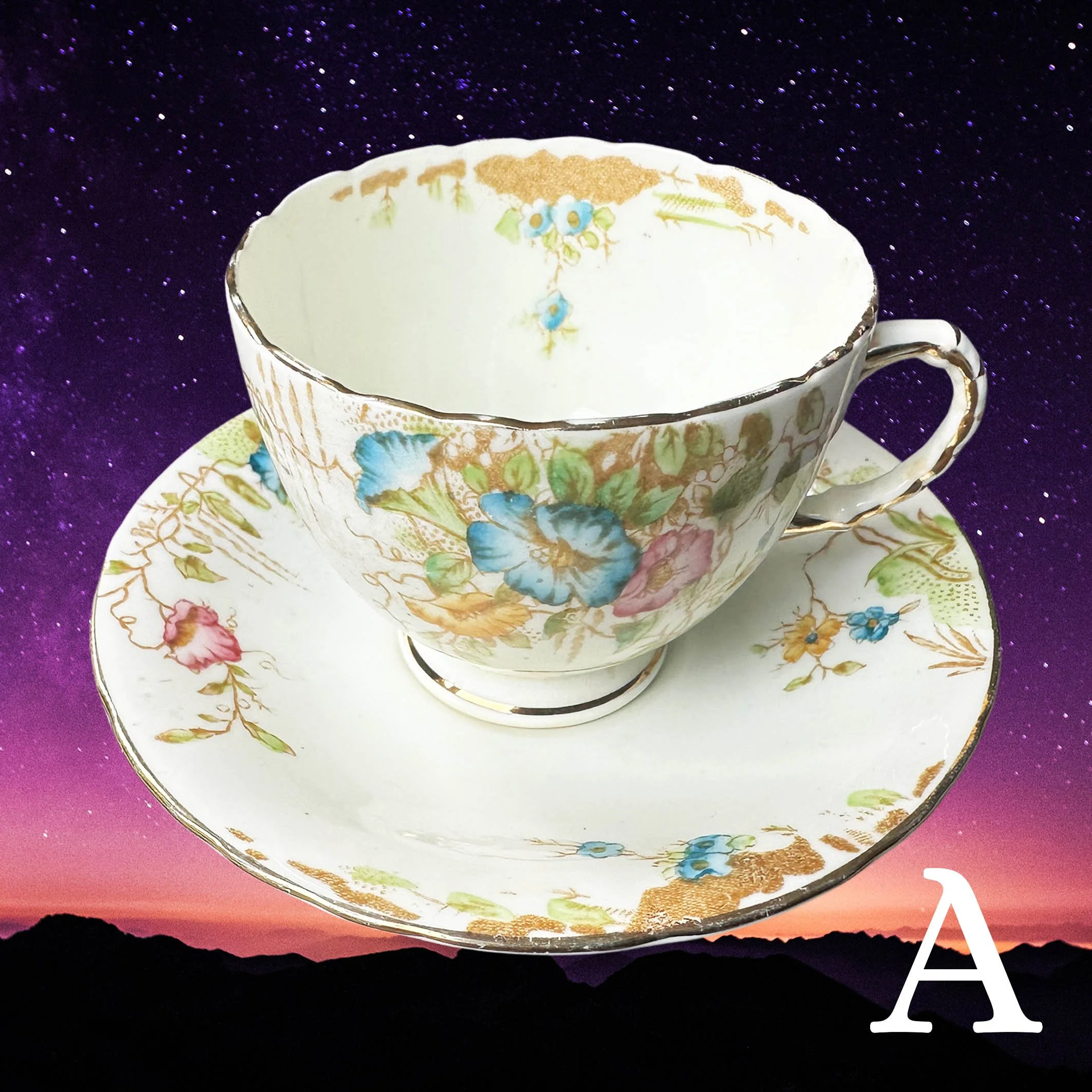 A vintage tea cup and saucer with a floral design and the word “Cunt” in black cursive writing