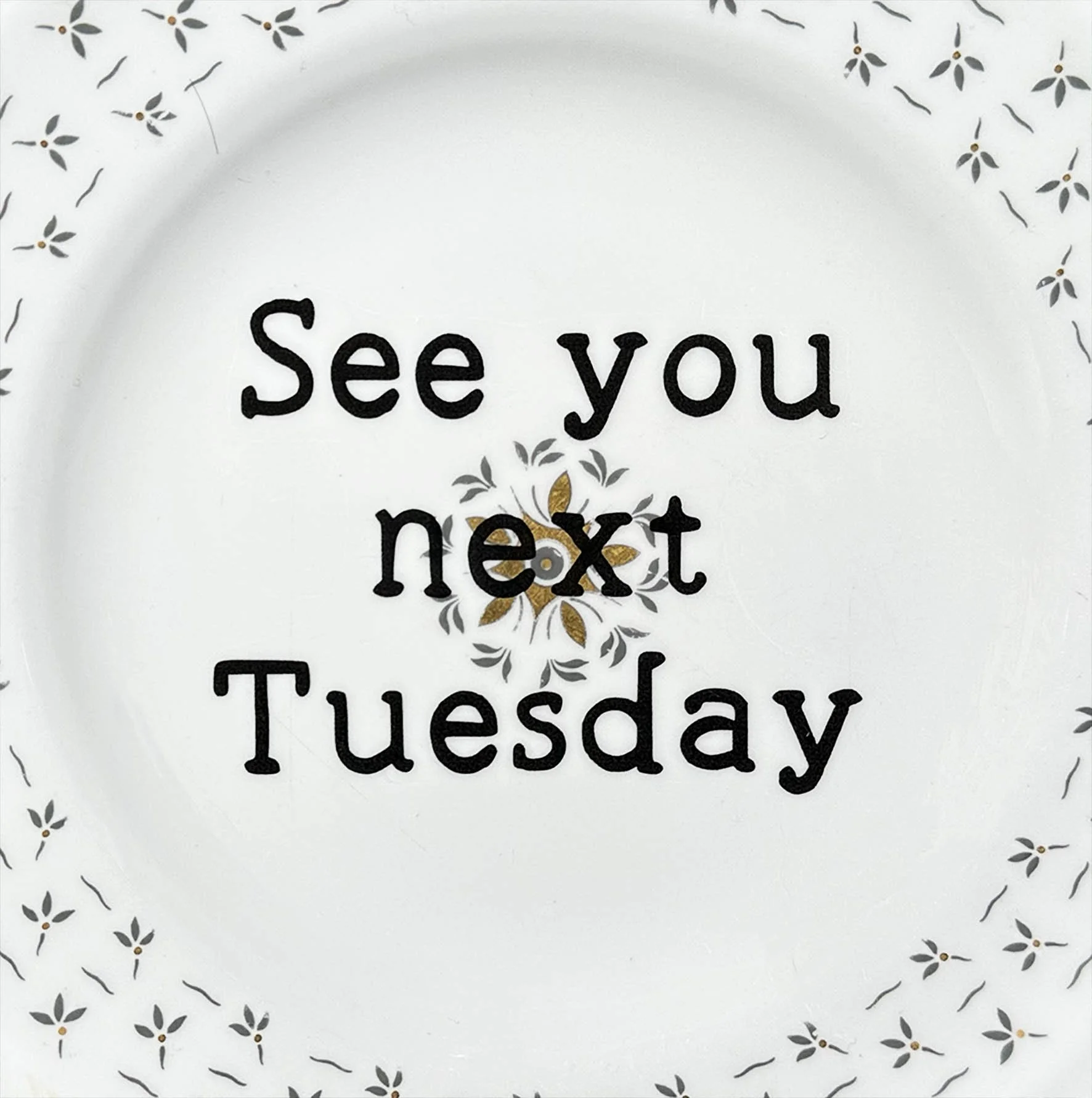 A vintage plate with blue flowers and the quote “see you next Tuesday”