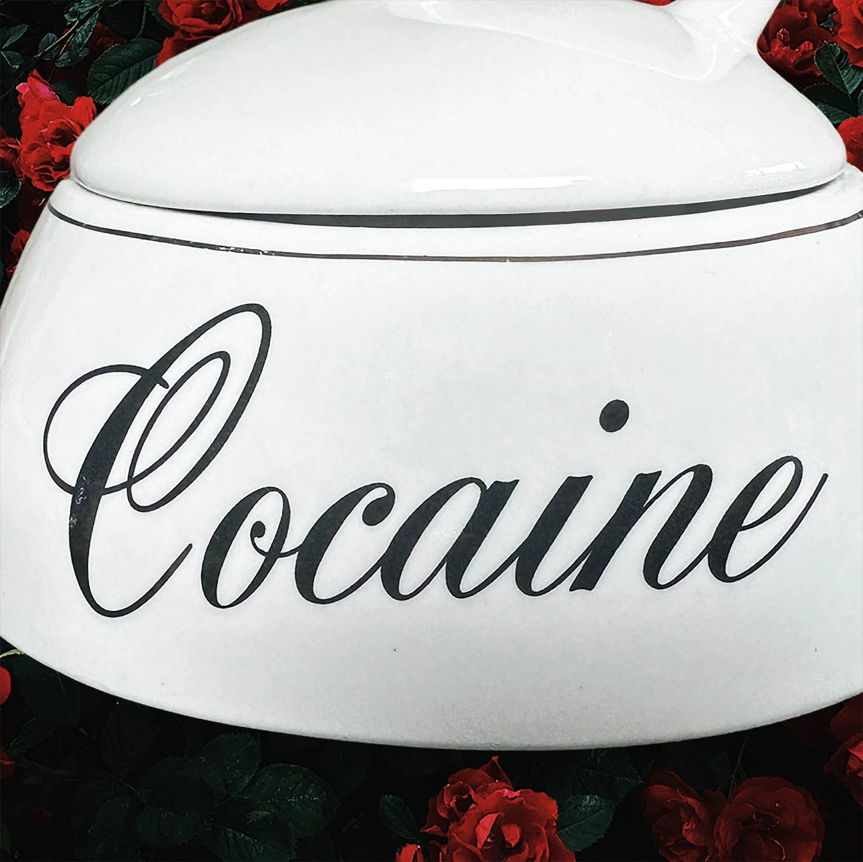 A vintage trinket jar with the word “cocaine” in black writing