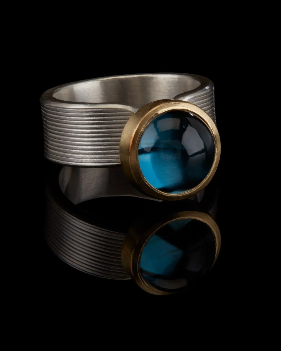 A fresh iteration of one of my favourite rings. Curved edge ring with the addition of a fine ribbed texture to the silver band. A lush deep blue topaz takes centre stage in a setting of 18ct gold. 

#madebyhand #handcrafted #contemporaryjewellery #fi
