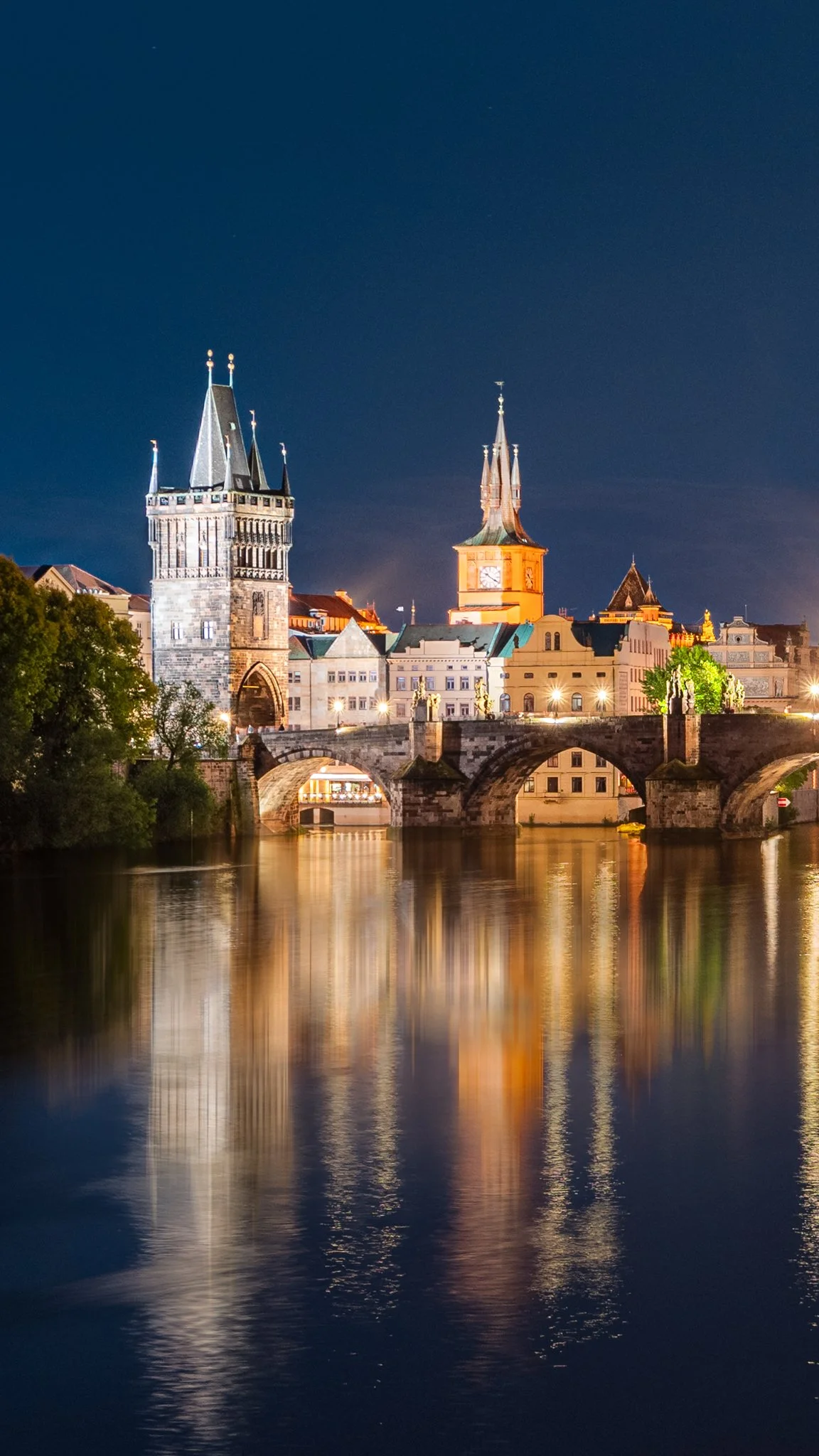 Veduta notturna del ponte di Karl e delle torri di Praga riflessi sul fiume Moldava.