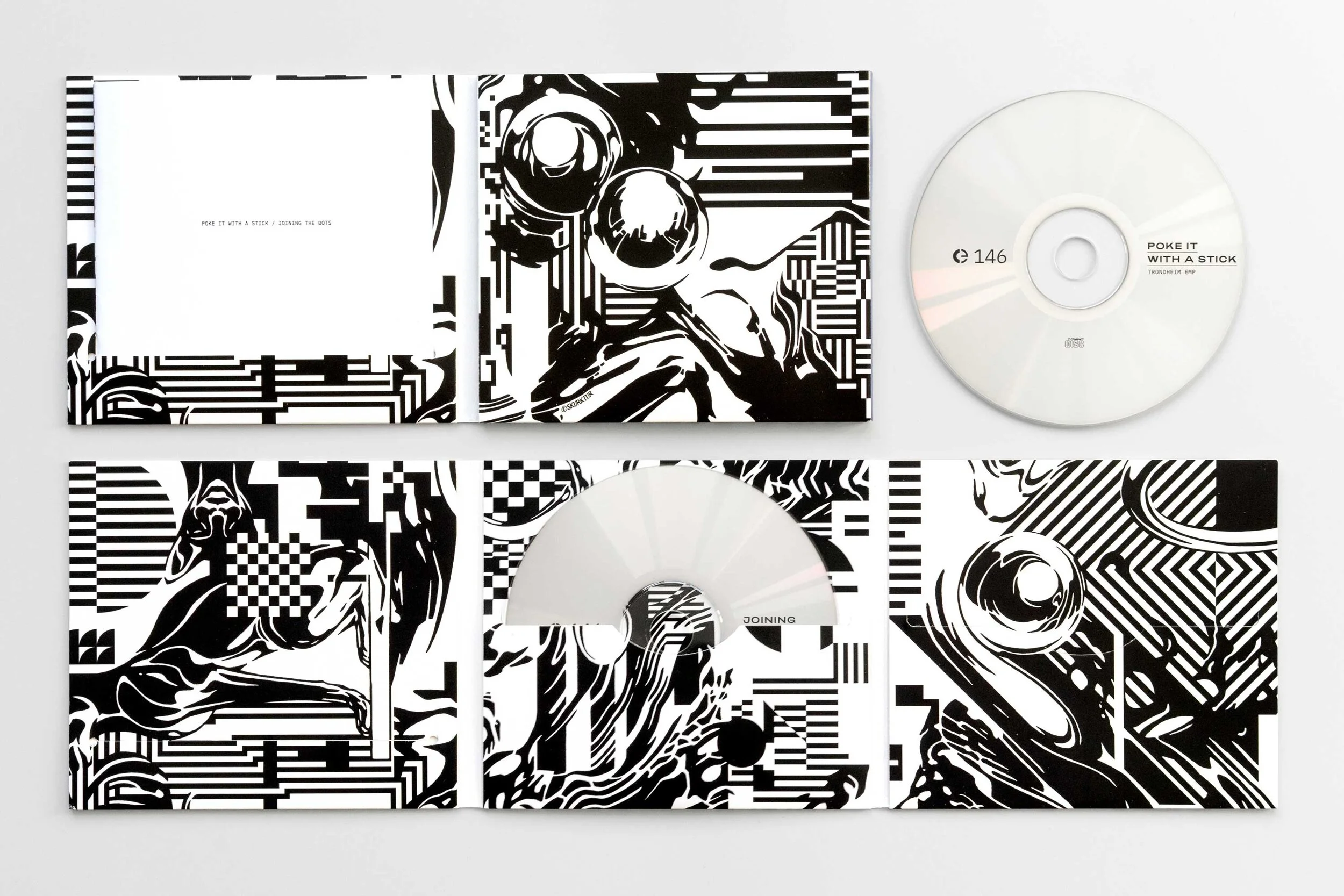 Two vinyl records with black and white abstract artwork, one partially inside a sleeve and the other outside, with a booklet showing graphic designs.