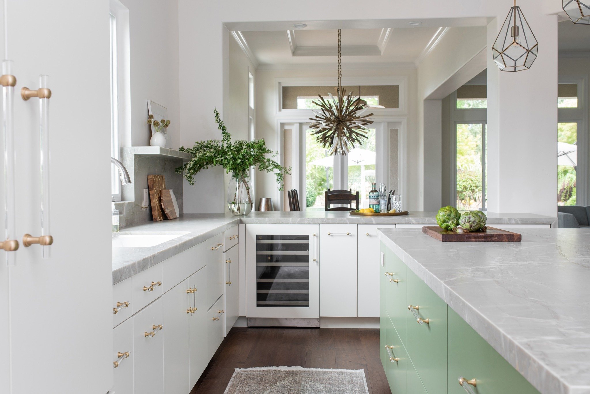 We are back to the real world after a week off and this shot is giving us all the spring feels- from the splash of sunlight through the window to the soft green island. Acrylic pulls and glam lighting finish off the space, with every detail a nod to 