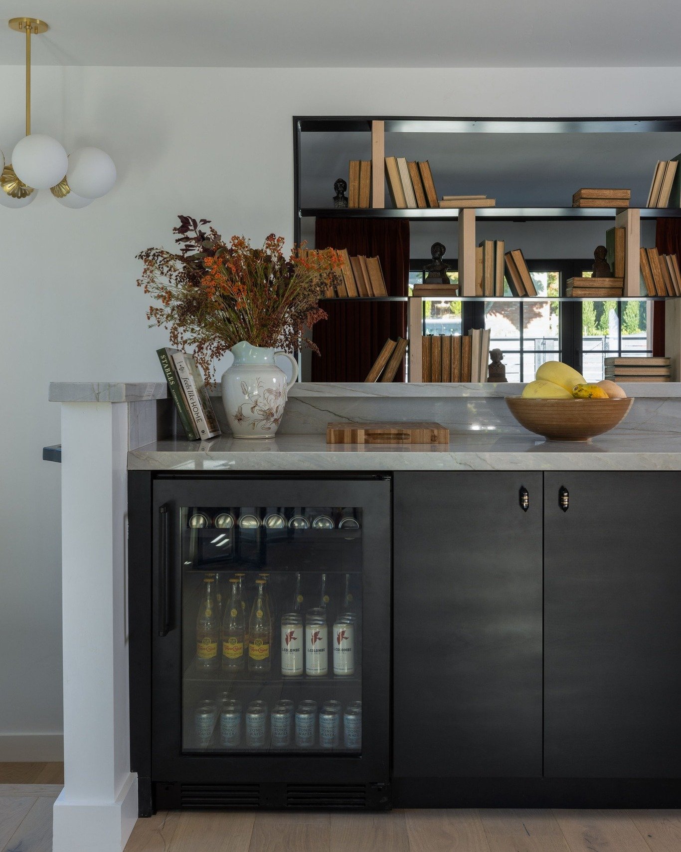 When a kitchen has a disconnected space, our first thought is to create a bar or beverage station. It gives a gathering place that is out of the way of the food prep and enlarges the kitchen footprint.

We opened the wall above the bar and added meta