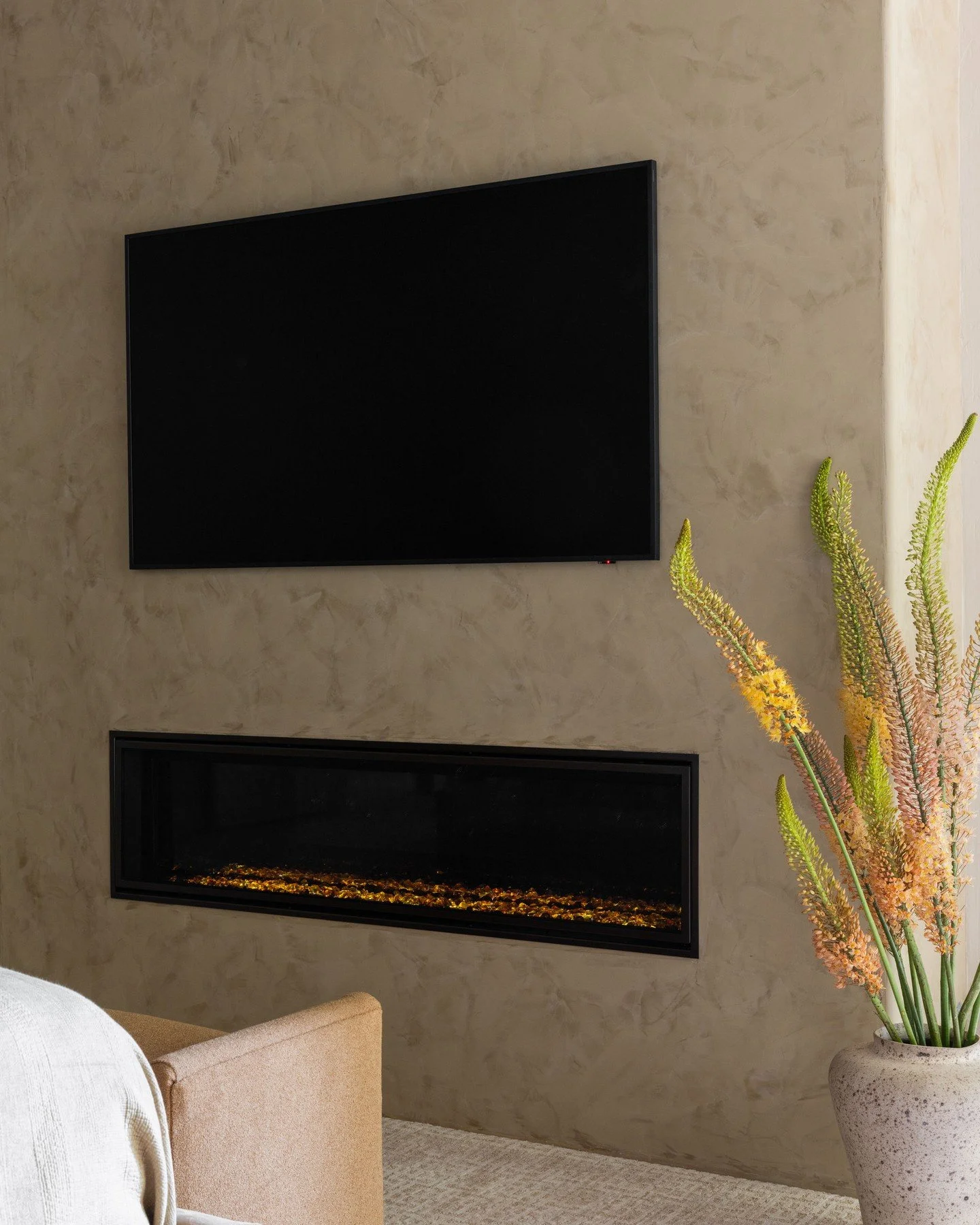 Warm linear flame + textured plaster + a centered focal point = the fireplace this room always needed.

📸: @nicolediannephoto
Styling by: @emilyairoso