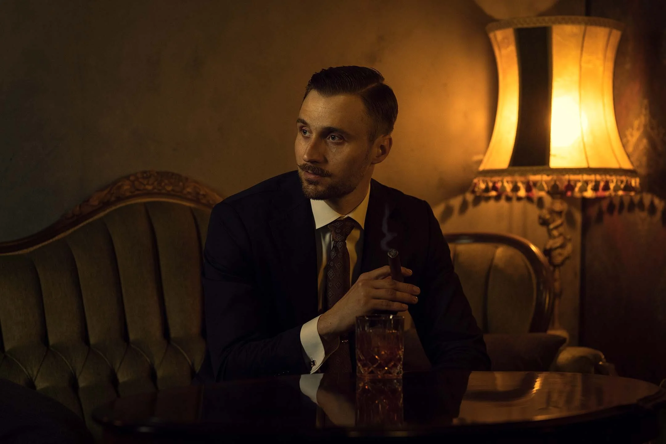 Tyylikäs ja arvokas muotokuvaus perinteisessä miljöössä – mies istumassa nojatuolissa