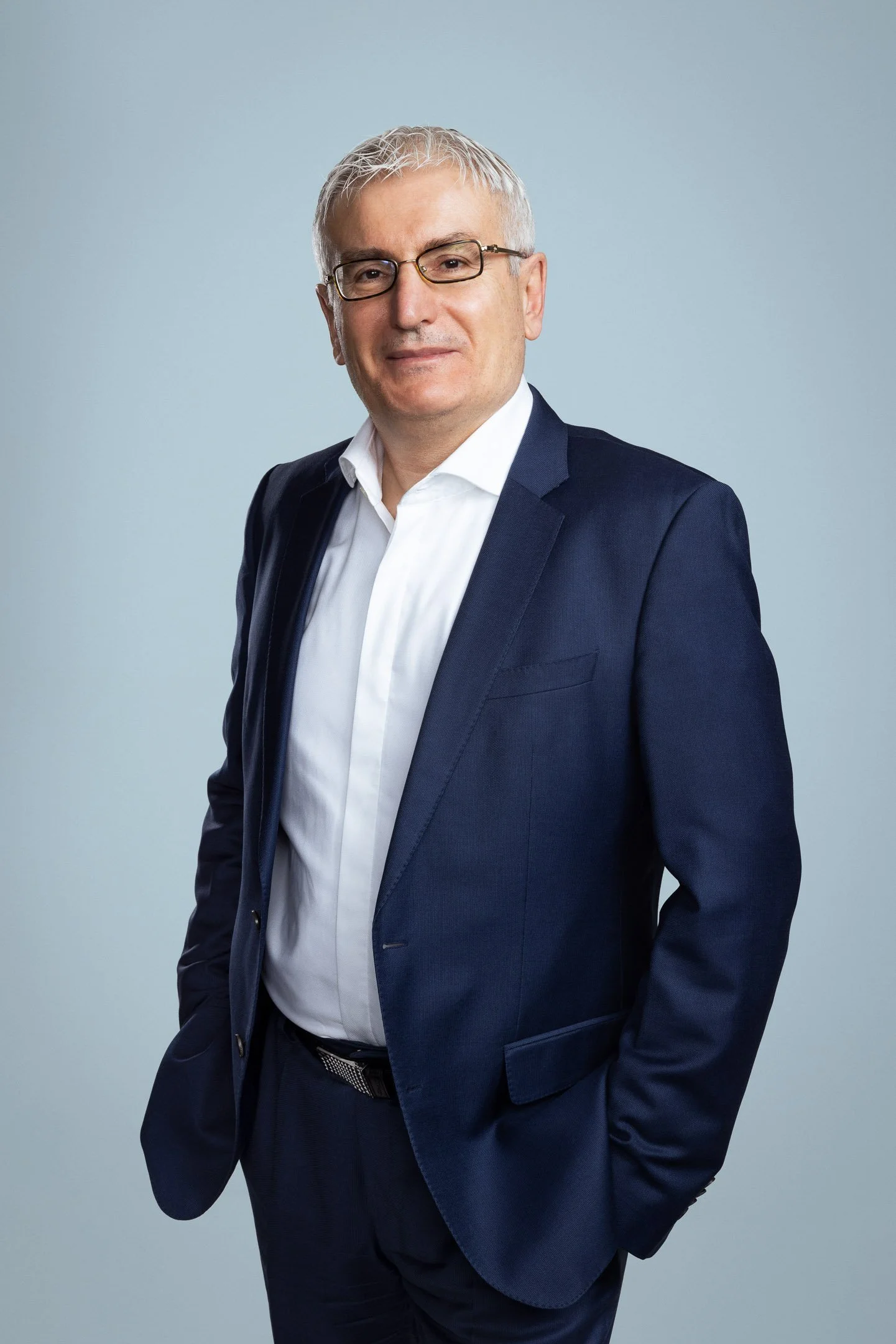 Luottamusta herättävä LinkedIn-profiilikuva ja yrityskuvaus – mies sinisessä puvussa ja silmälaseissa.