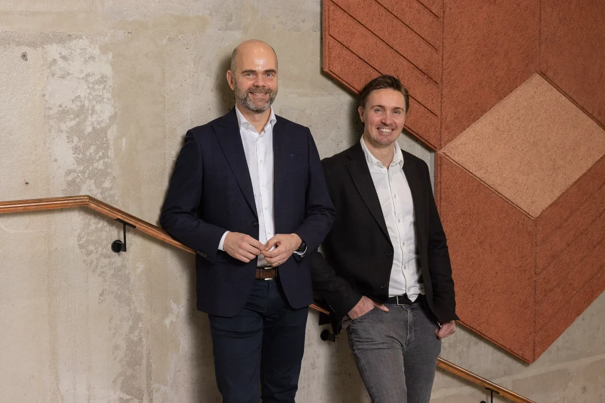 Moderni yrityskuvaus aidoissa tiloissa – kaksi miestä keskustelemassa toimiston portaikoissa.