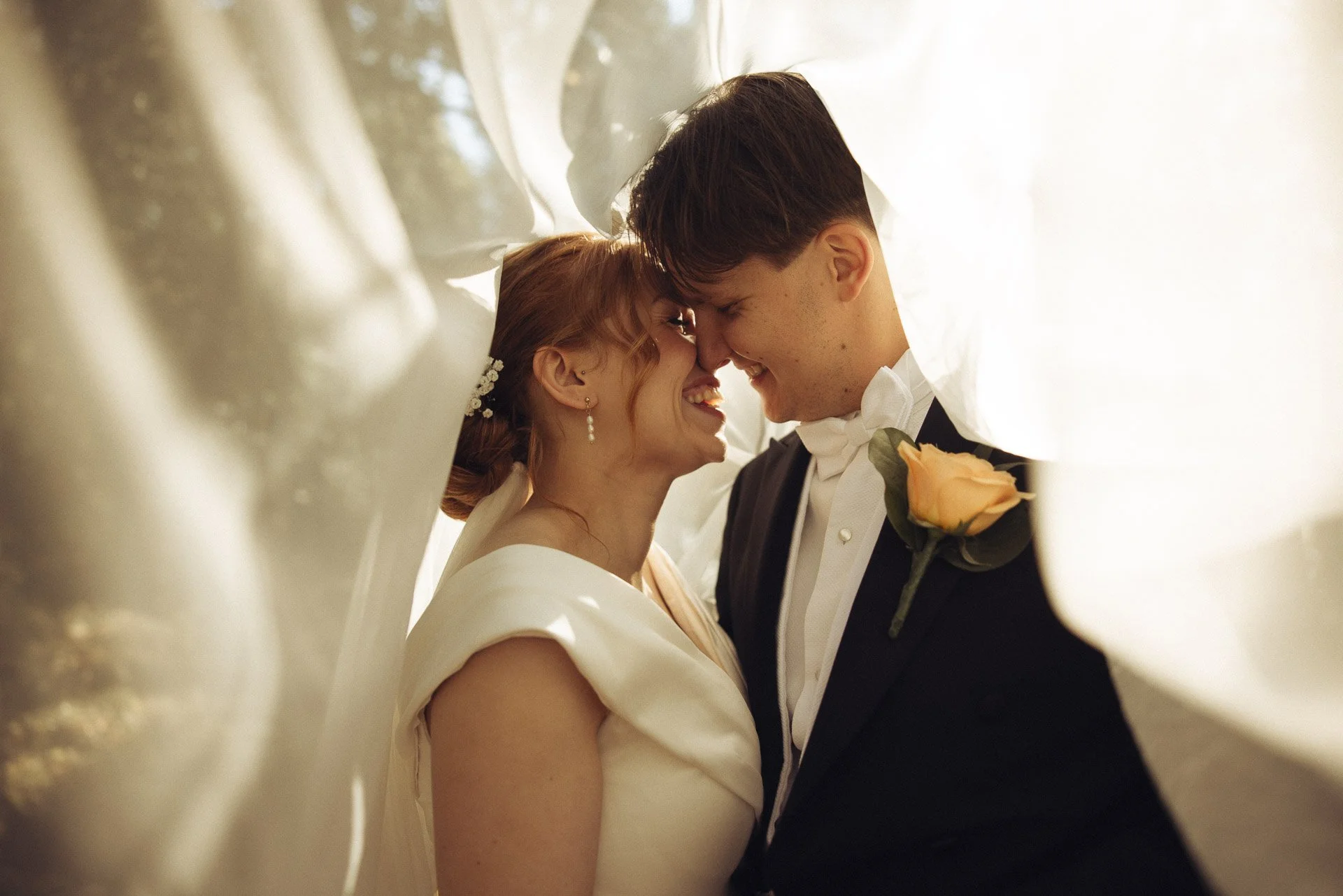 Lähikuva hääparista valkoisen kankaan alla