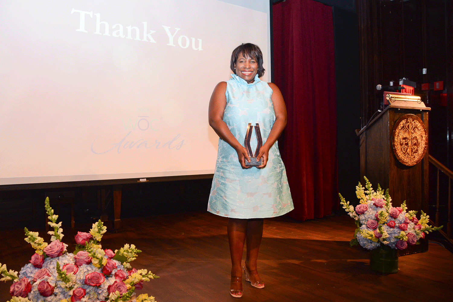 2023-woc-awards-v-renee-cutting-holding-award-on-stage.png